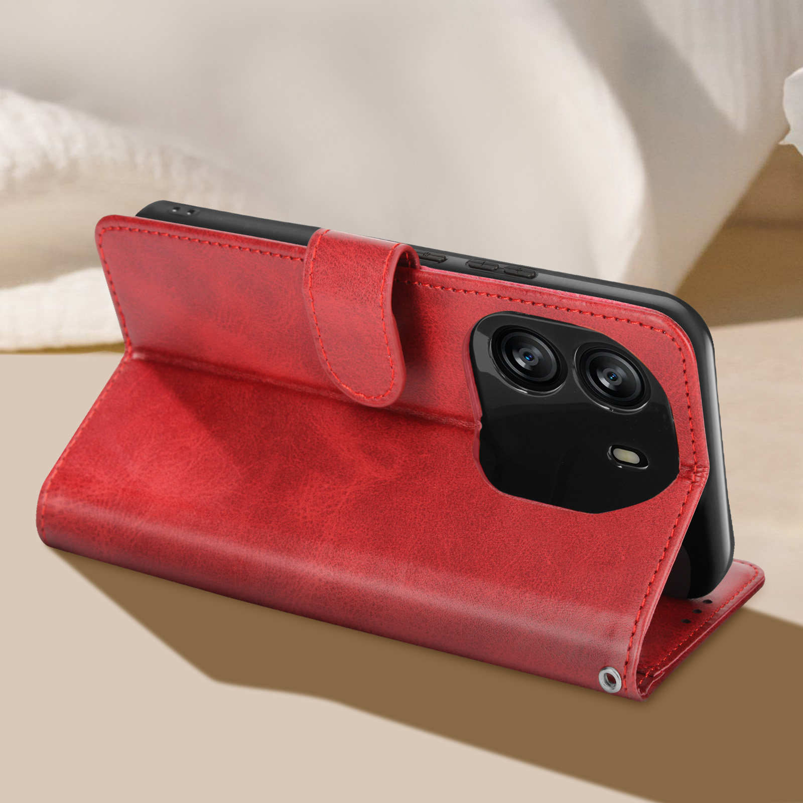 Eine rote Handyhülle mit einem Telefon darin ist geöffnet und liegt auf einer Oberfläche.