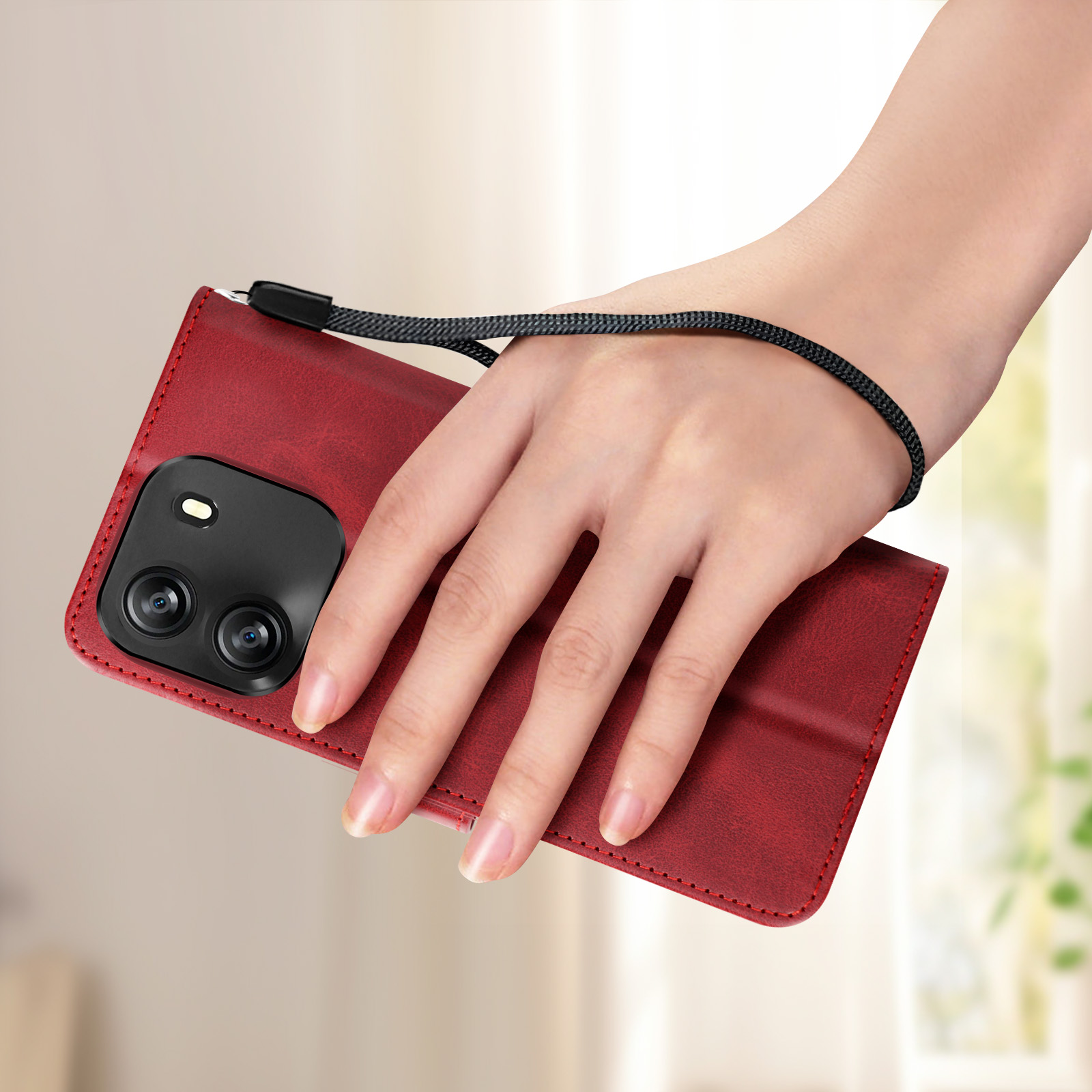 Hand, die eine rote Handyhülle mit schwarzer Handschlaufe hält.