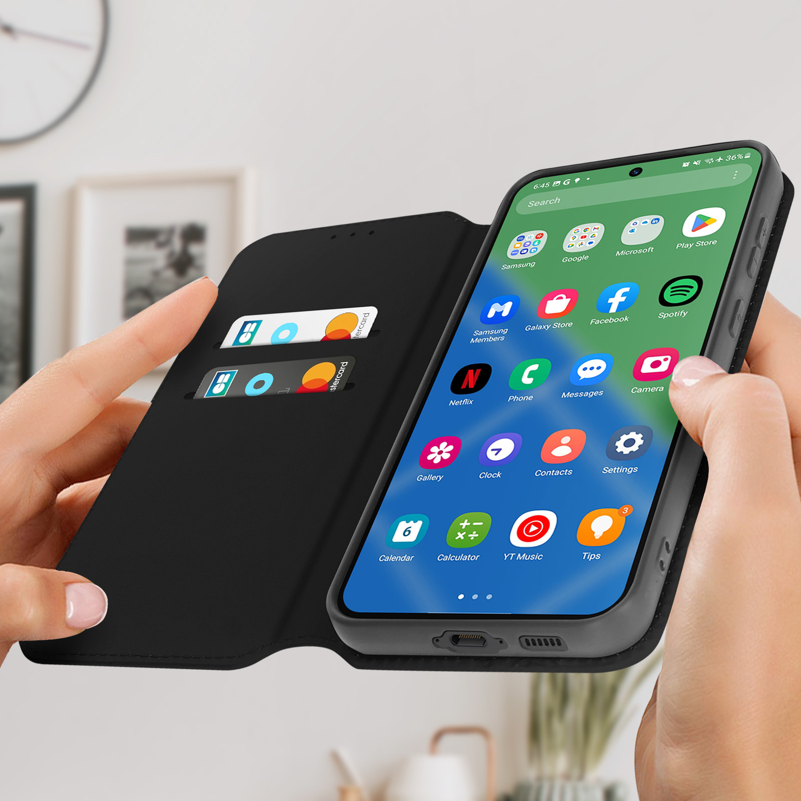 Mani che tengono un telefono in una custodia nera. Il telefono mostra le app, inclusa l'app Impostazioni.