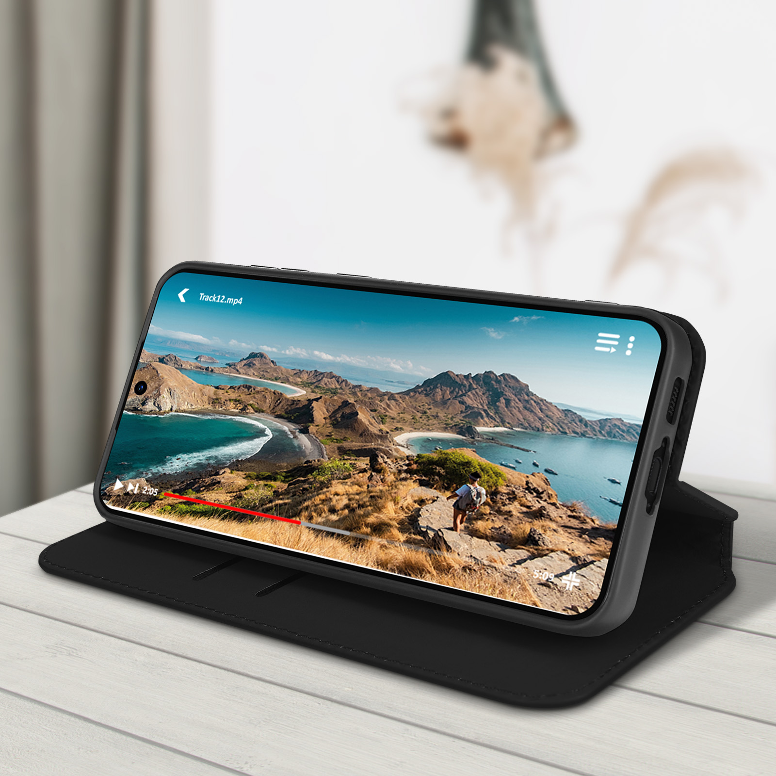 Un telefono in una custodia nera mostra un video di un paesaggio panoramico.