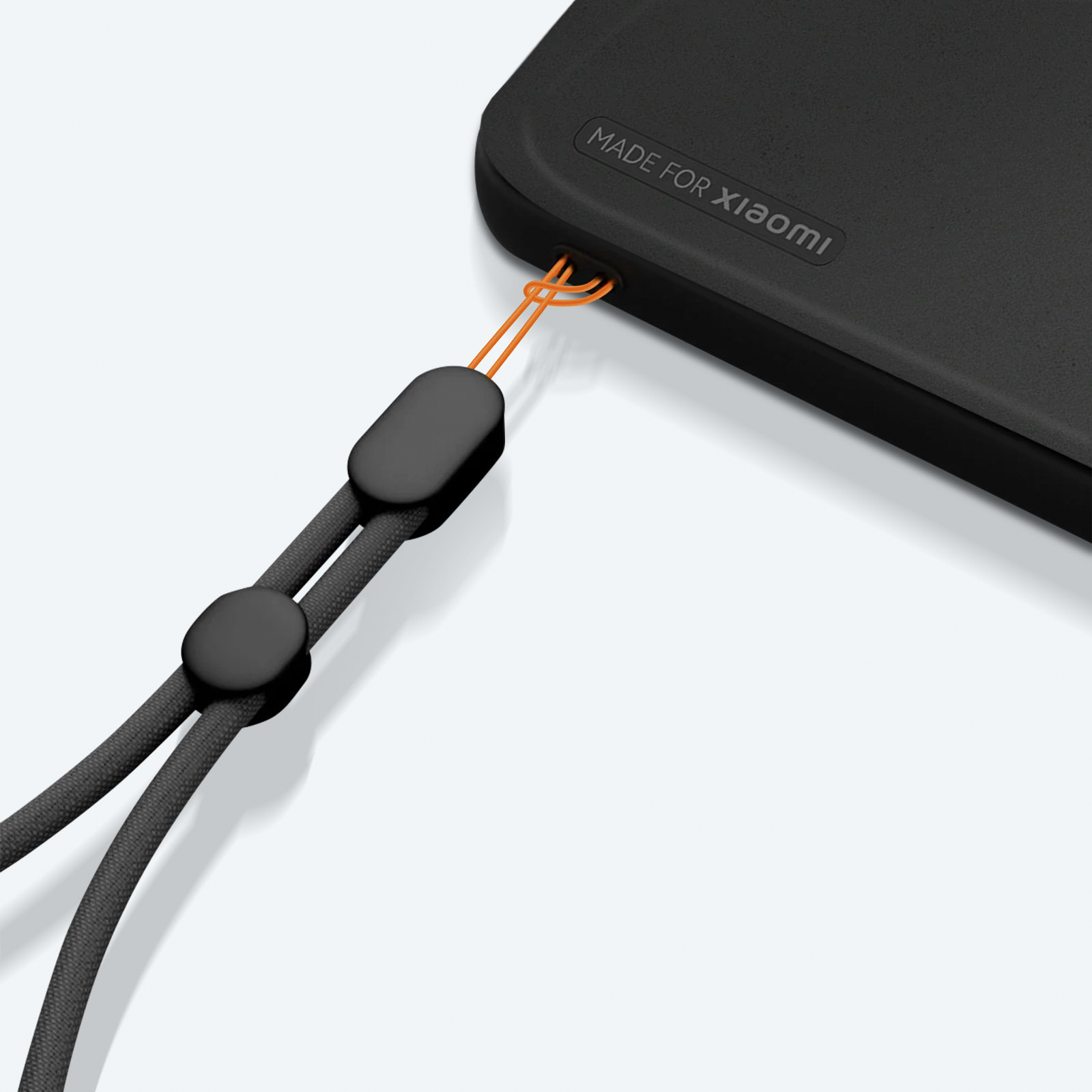 Zwarte telefoonhoes met een riem. Riem is zwart met oranje koorddetails. Witte achtergrond.