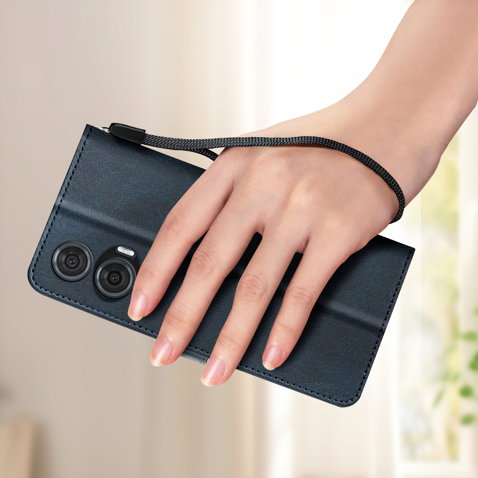 Mano che tiene una custodia per telefono blu scuro chiusa con cinturino e tre fotocamere.