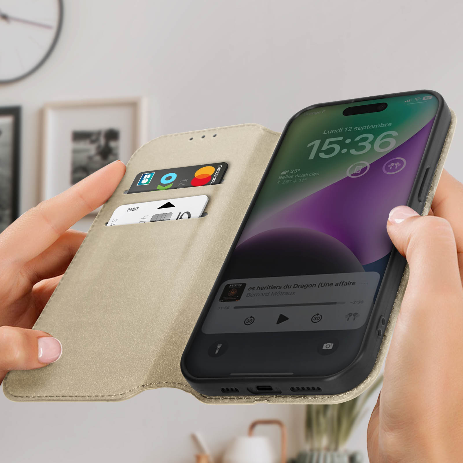 Mani che tengono un telefono in una custodia beige aperta. Il telefono visualizza l'orologio e il menu.