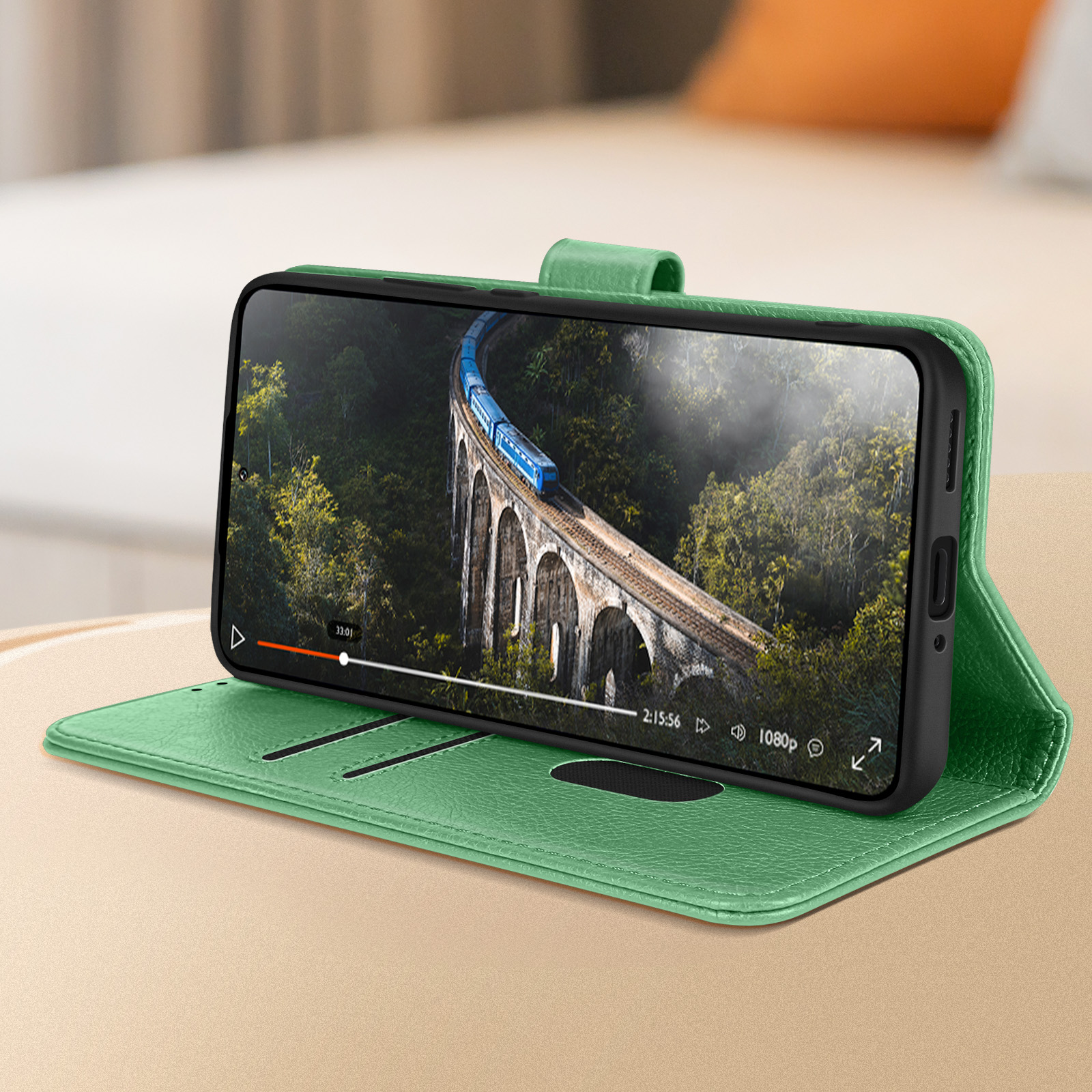 Telefon in grüner Hülle, das ein Video abspielt. Hintergrund: Brücke. Hülle ist offen.