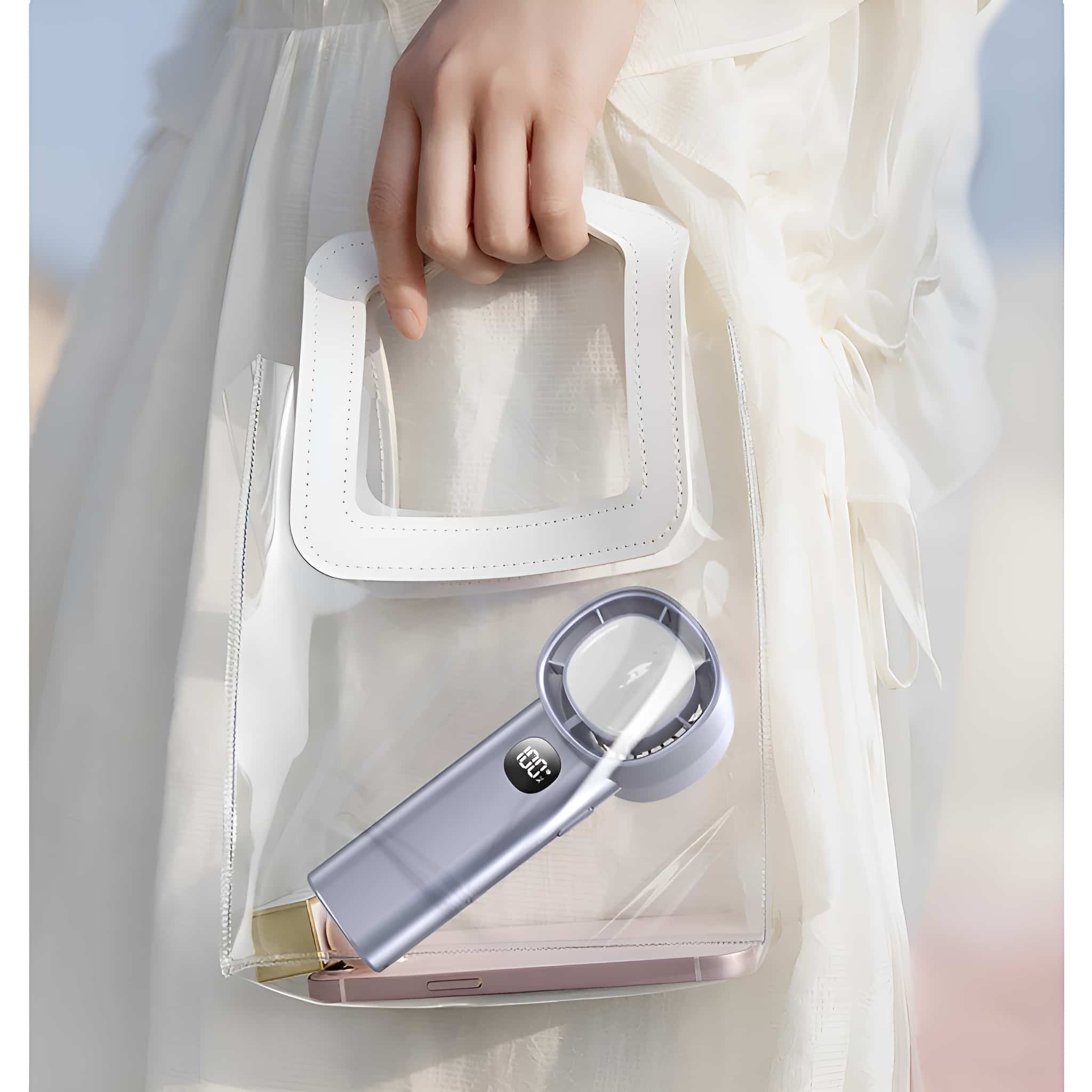 Frau hält transparente Tragetasche mit kleinem Ventilator. Telefon in der Tasche. Weißer Hintergrund.