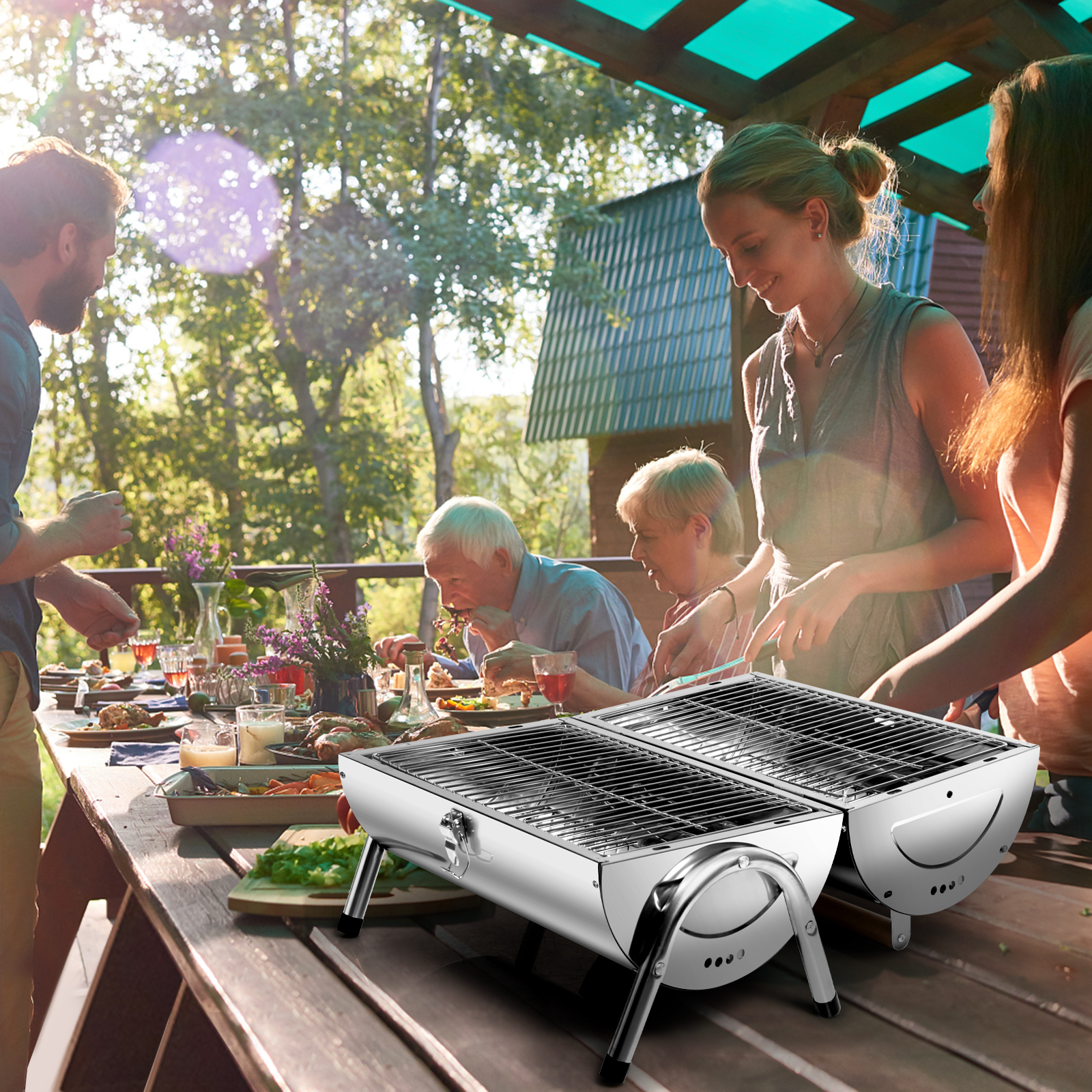 Familie beim Picknick mit zwei Grills auf einem Tisch. Grüne Bäume und blauer Himmel im Hintergrund.
