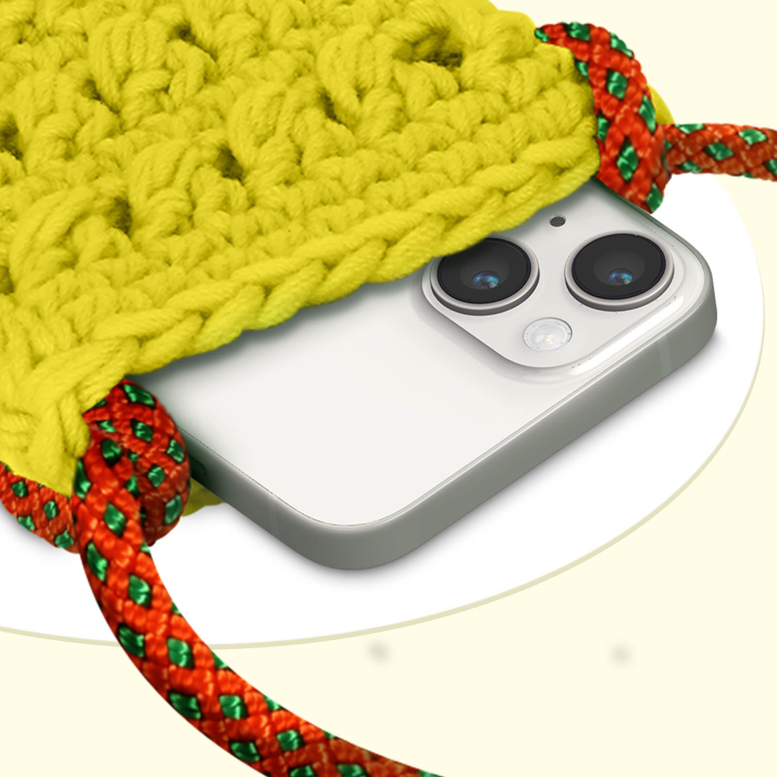 Telefono in una custodia gialla all'uncinetto con cinturino rosso e verde. Le fotocamere del telefono sono visibili.