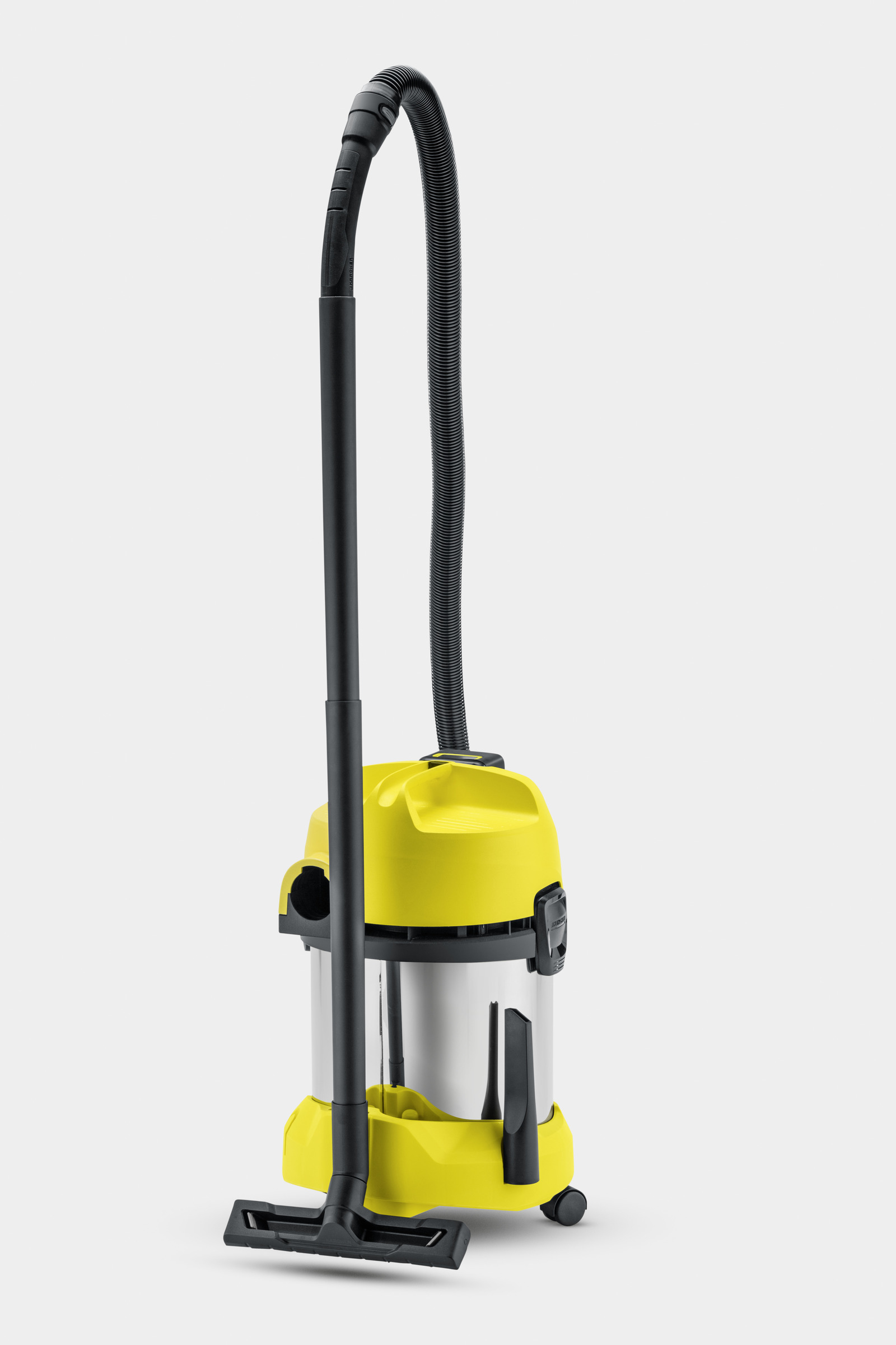 Un aspirateur jaune et argenté avec un tuyau et une buse noirs. Il est debout.