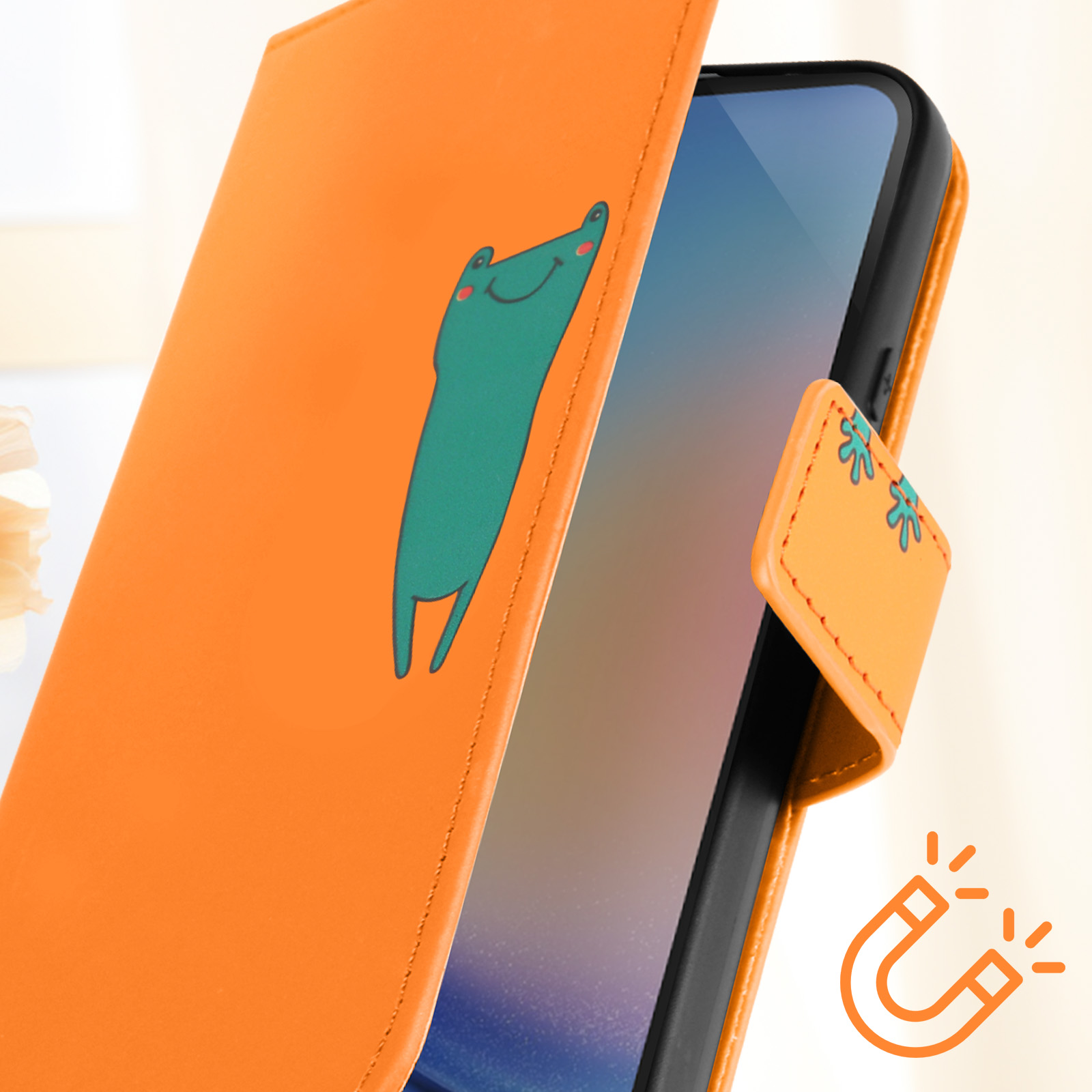 Custodia arancione per telefono con un ranocchio dei cartoni animati sulla copertina. Viene mostrato anche un simbolo magnetico.
