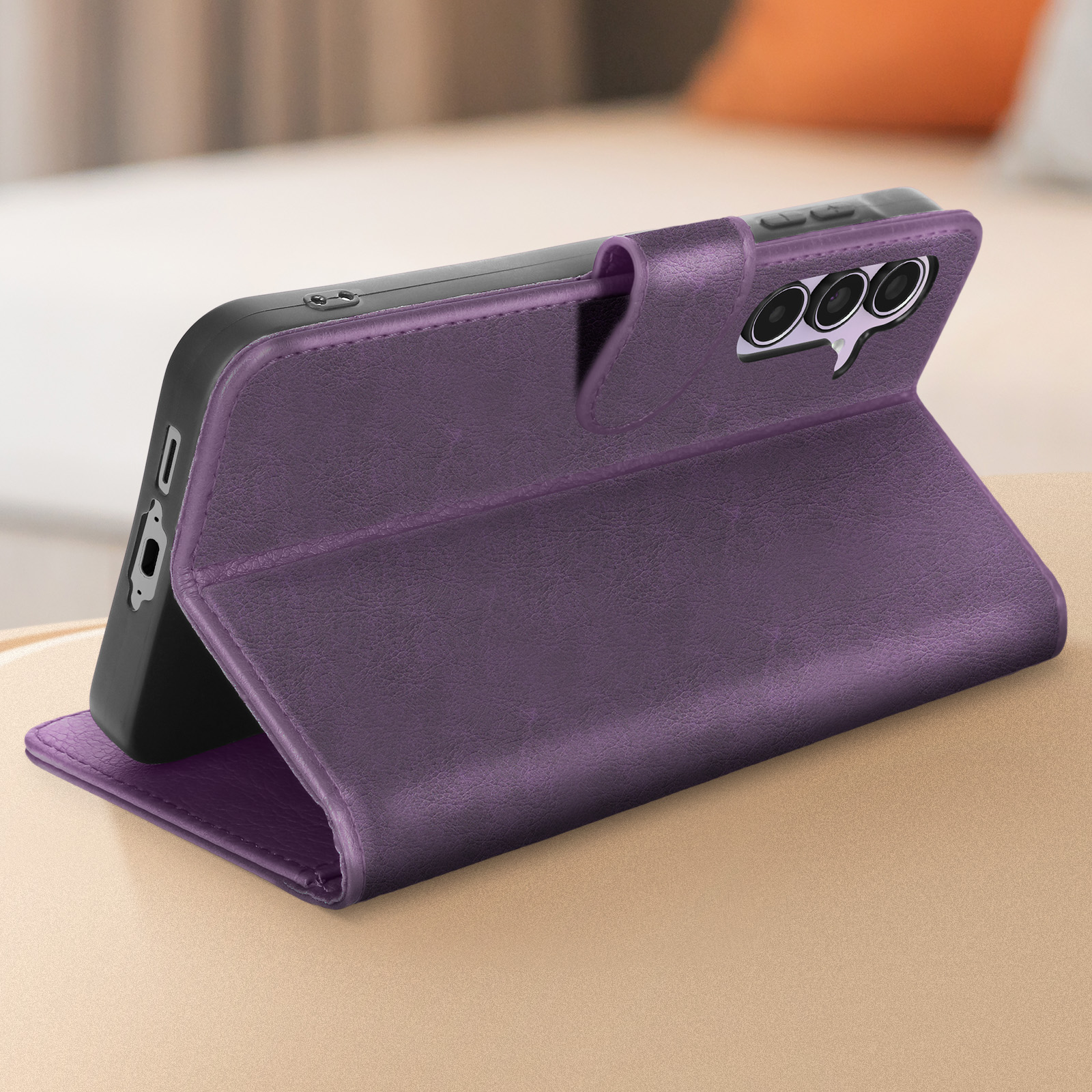 Custodia viola con telefono all'interno, in piedi su una superficie di legno. Tre lenti della fotocamera visibili.