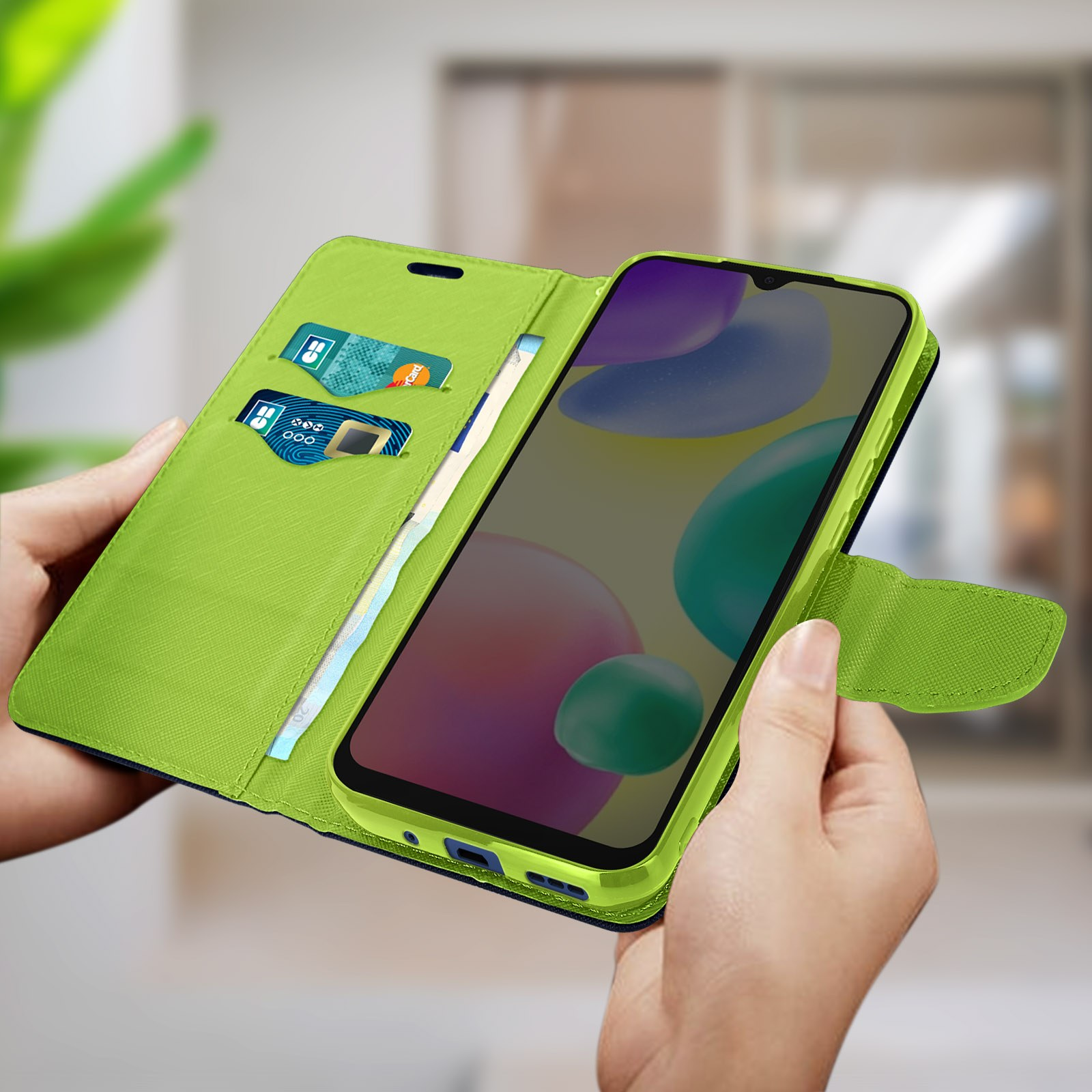 Mani che tengono una custodia per telefono verde con un telefono e carte.