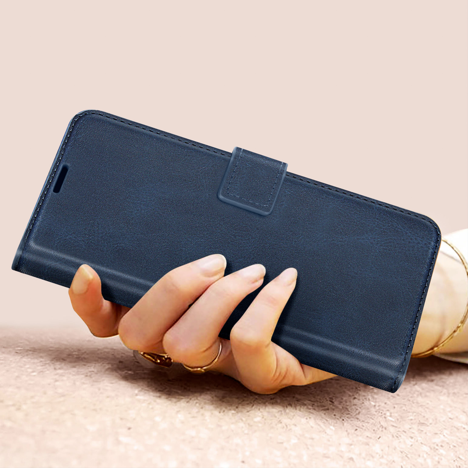 Una custodia per telefono blu navy con chiusura a scatto. La custodia del telefono viene tenuta.