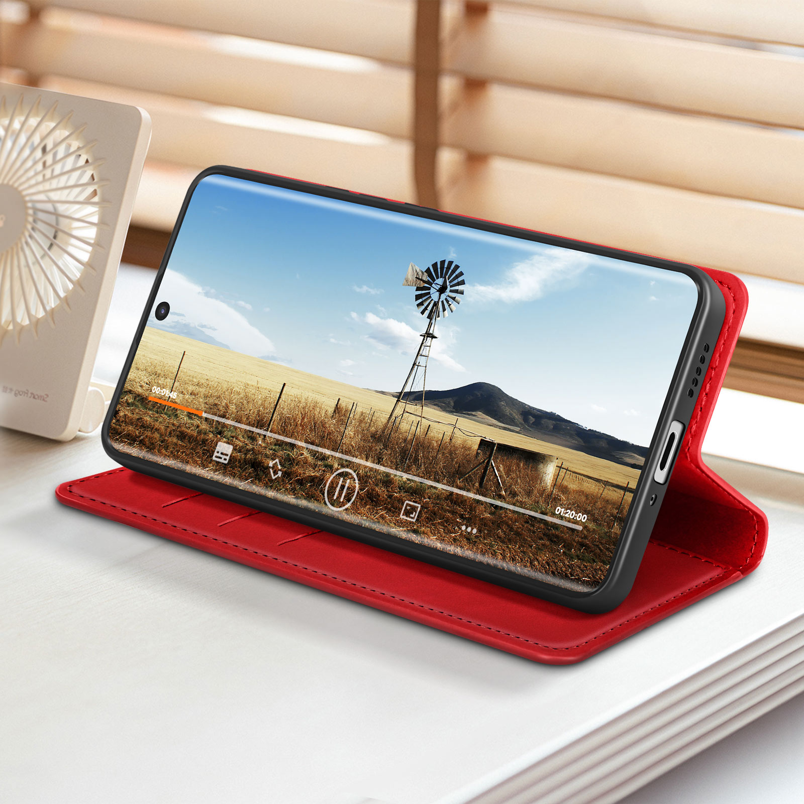 Un telefono mostra un video in una custodia rossa.