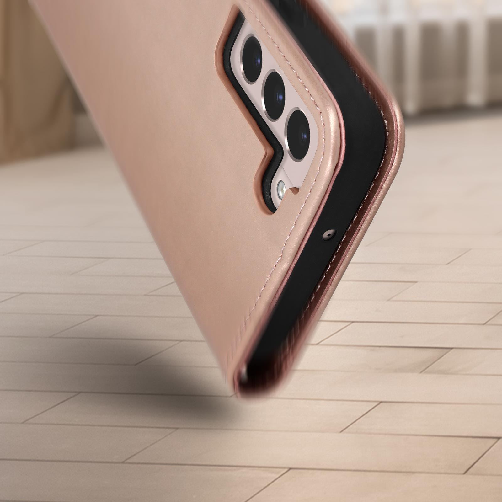 Custodia oro rosa, primo piano, mostra la fotocamera e parte del telefono. La custodia è aperta.