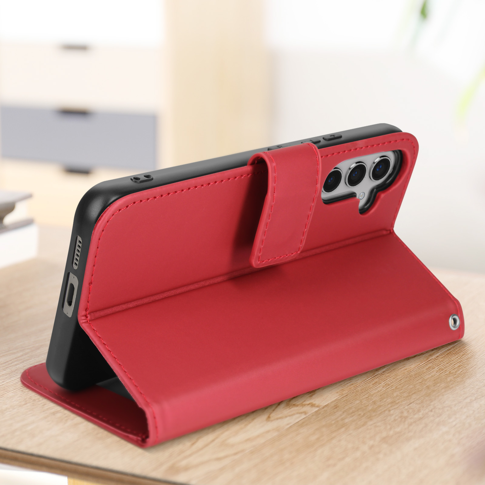 Rote Handyhülle mit Telefon darin, liegt auf einem Holztisch. Die Hülle ist offen.