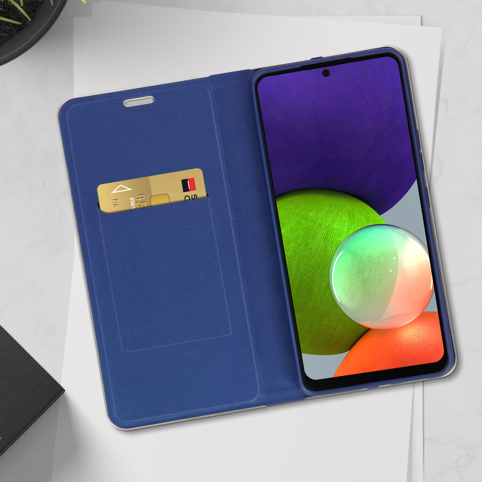 Custodia per telefono blu aperta. Telefono dentro. Carta di credito nello slot. Viola scuro e verde.