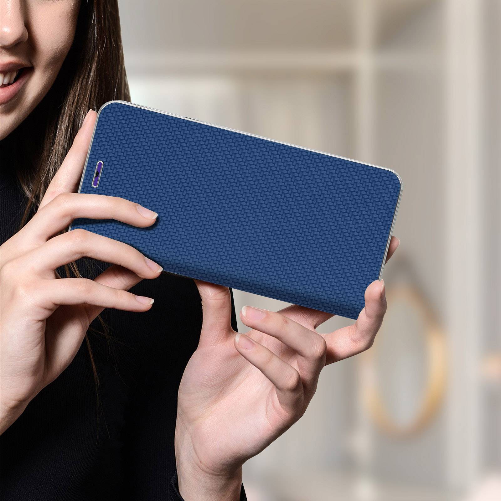 Donna che tiene una custodia blu per telefono con una trama intrecciata, che mostra la custodia chiusa.