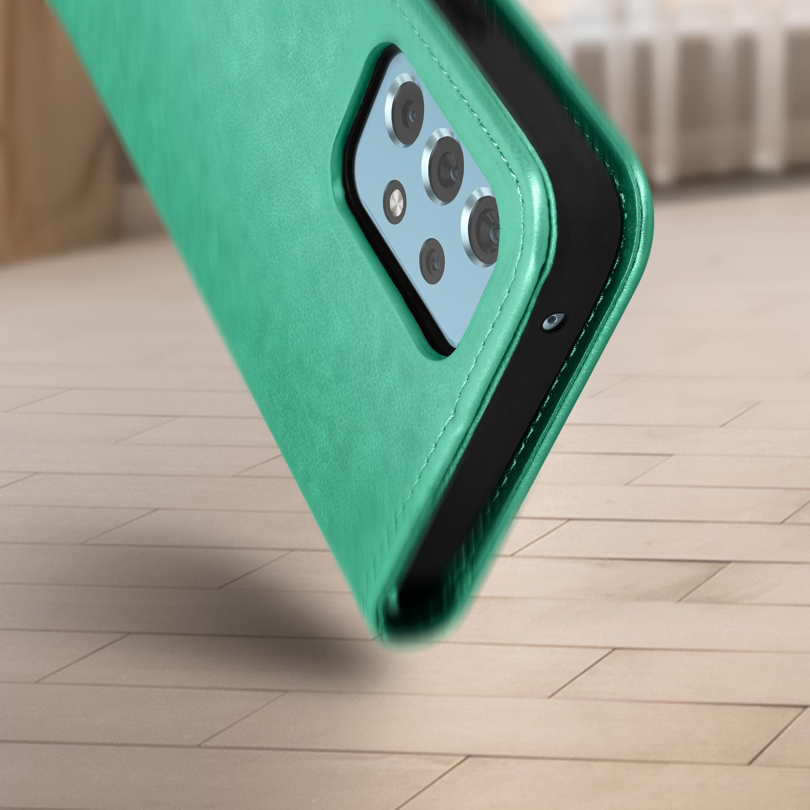 Custodia verde per telefono su una superficie di legno. La custodia copre la parte posteriore del telefono.