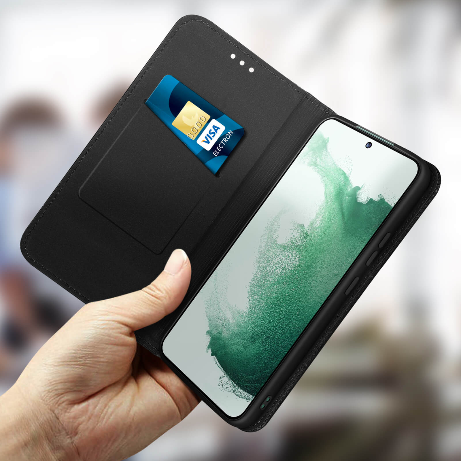 Main tenant un téléphone avec une carte de crédit dans l'étui. L'étui du téléphone est noir et ouvert.