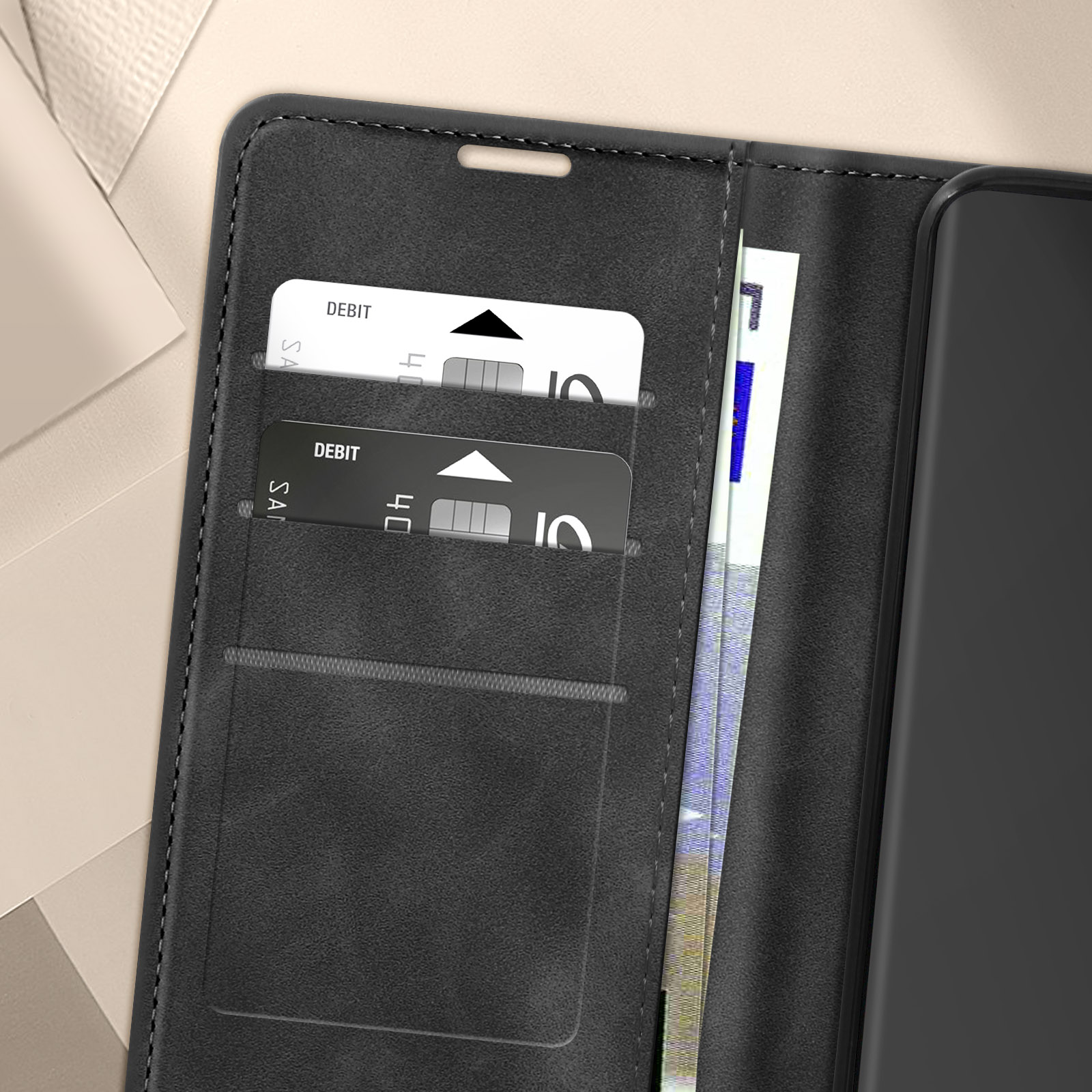 Un primo piano dell'interno di una custodia per telefono nera con fessure per carte e contanti. Sfondo bianco.