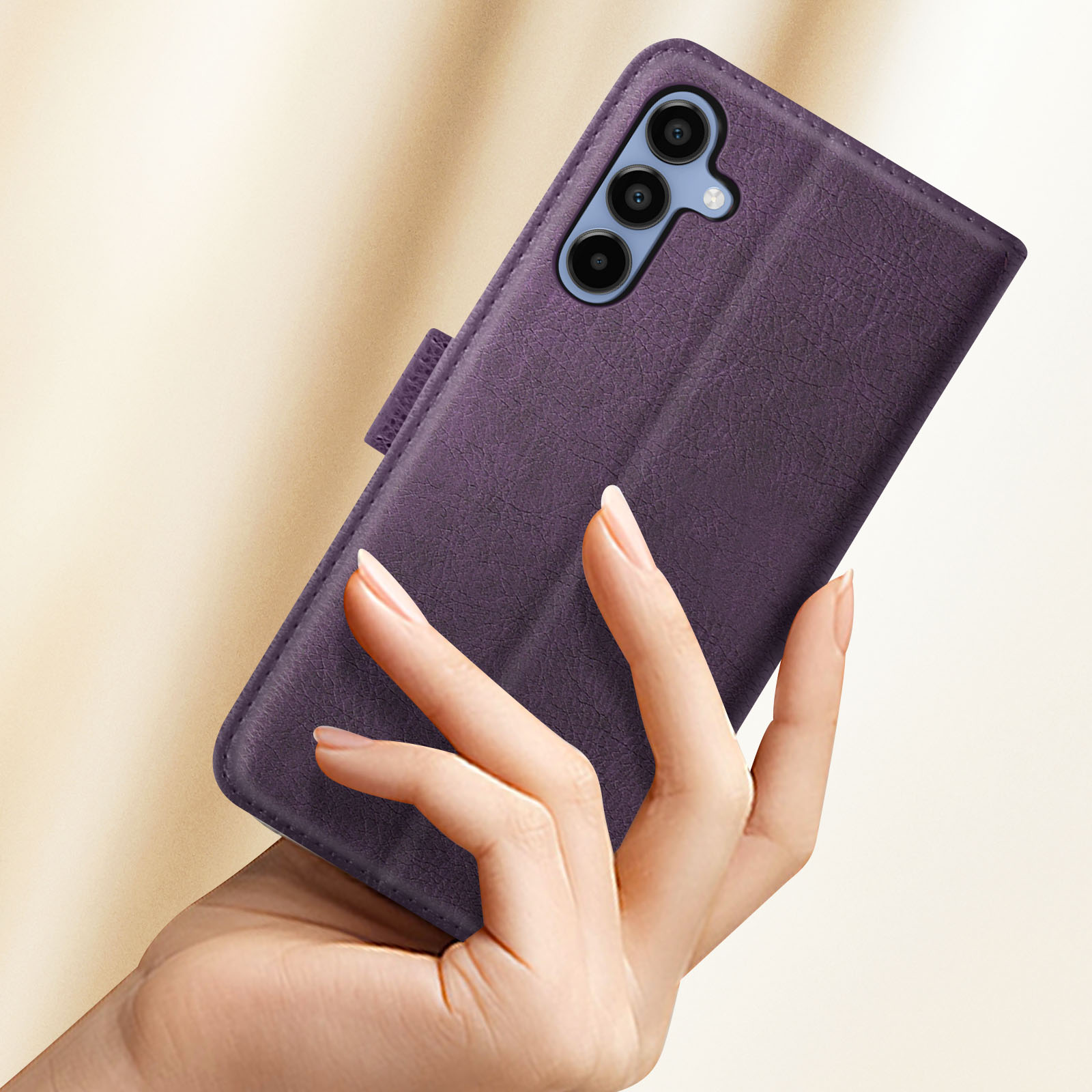Mano che tiene una custodia viola per telefono, mostrando la configurazione della fotocamera del telefono.