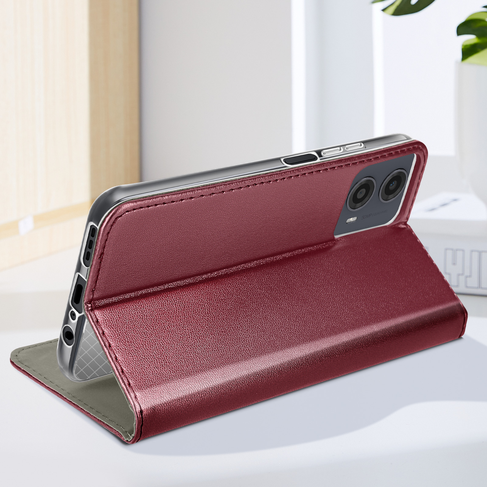 Geöffnete rote Leder-Handyhülle, ein Telefon eingesetzt, auf weißem Tisch, vor verschwommenem Hintergrund.