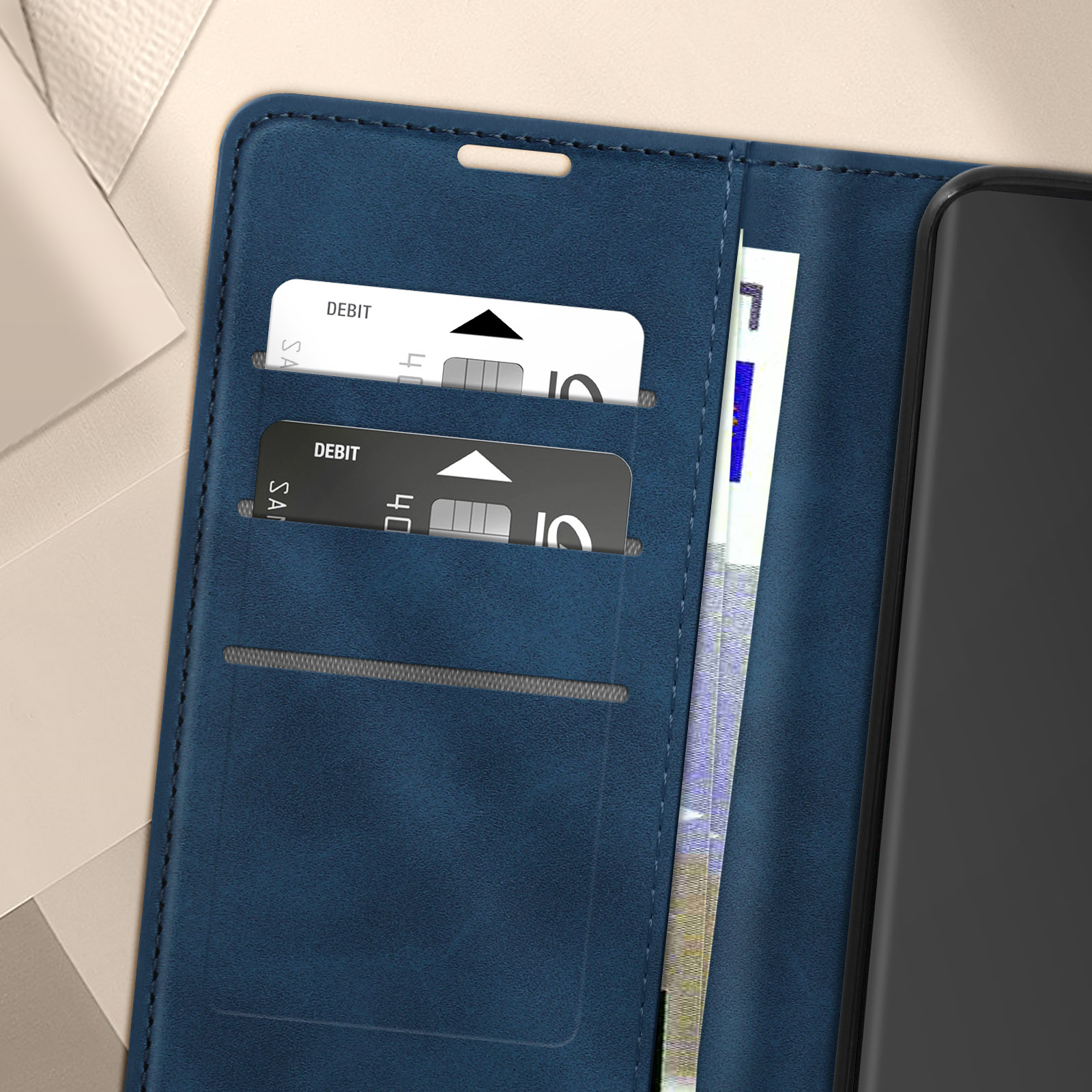Primo piano di una custodia blu con due carte di debito e una banconota all'interno.