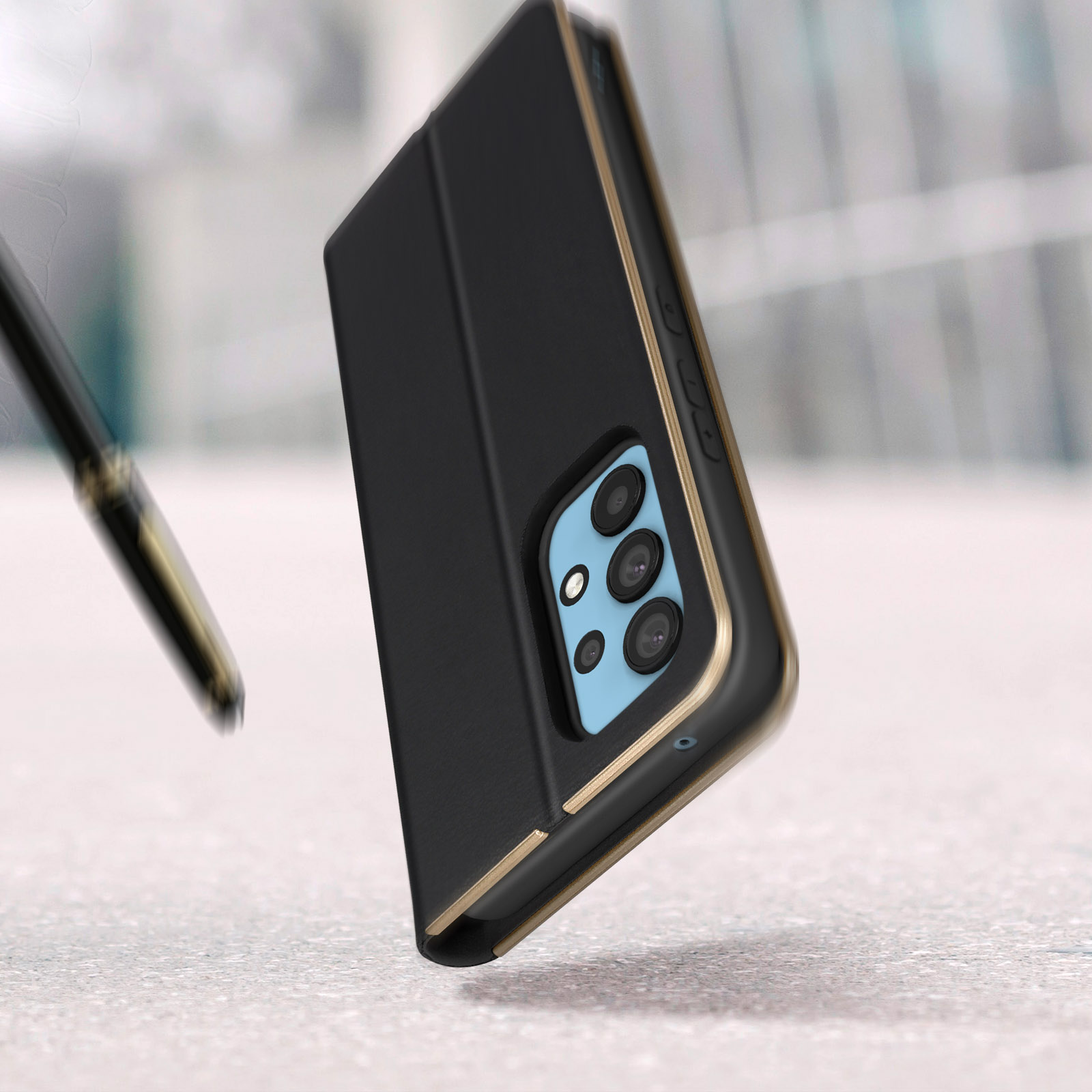 Custodia per telefono nera con finiture dorate, telefono all'interno. Una penna è a sinistra.