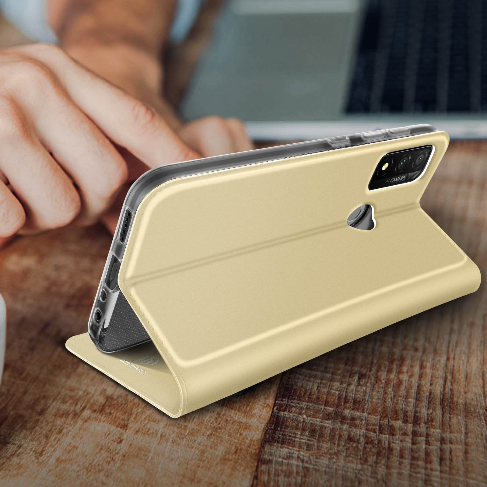Custodia dorata per telefono aperta su un tavolo di legno.