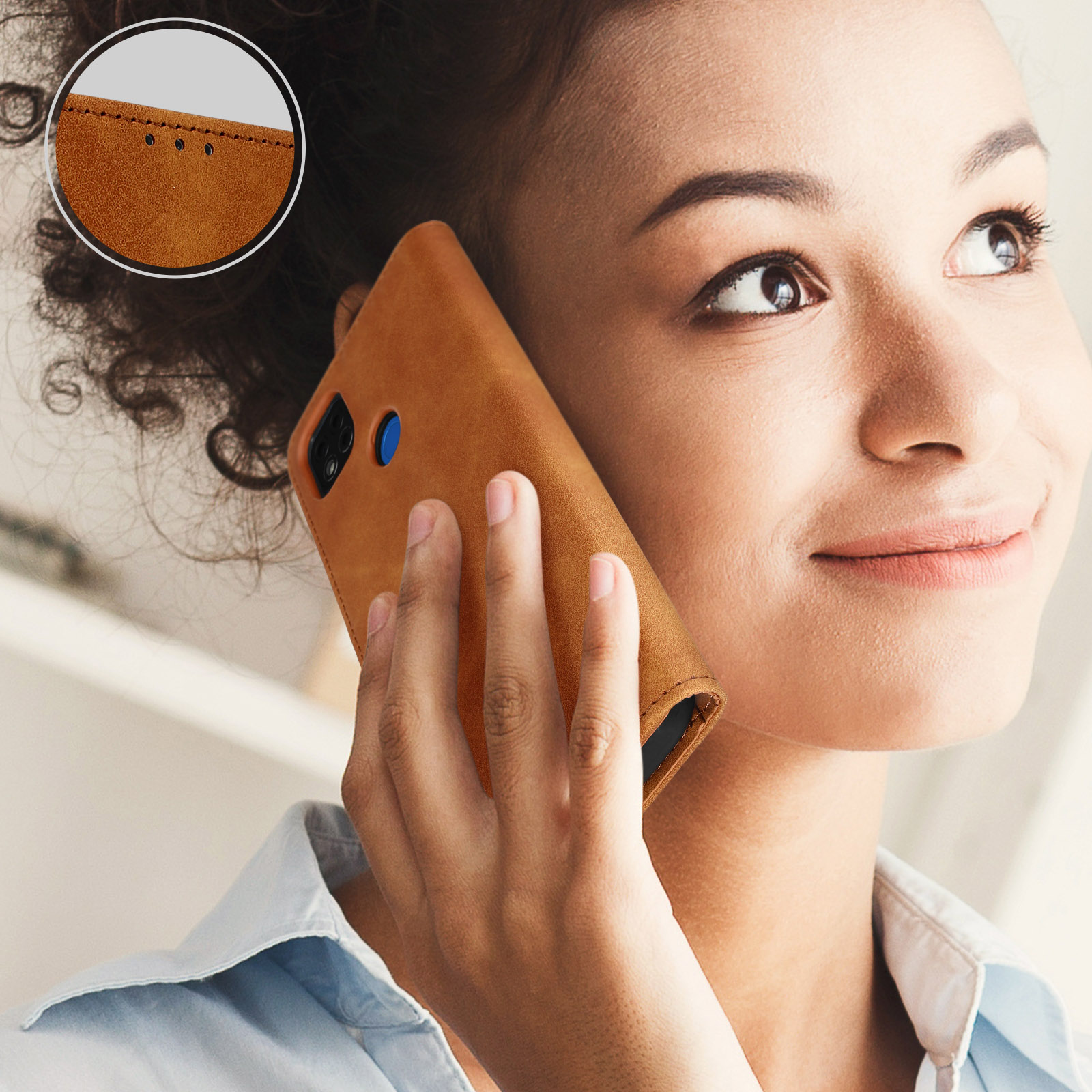 Donna che tiene un telefono all'orecchio. Il telefono è in una custodia marrone. La donna sta sorridendo.