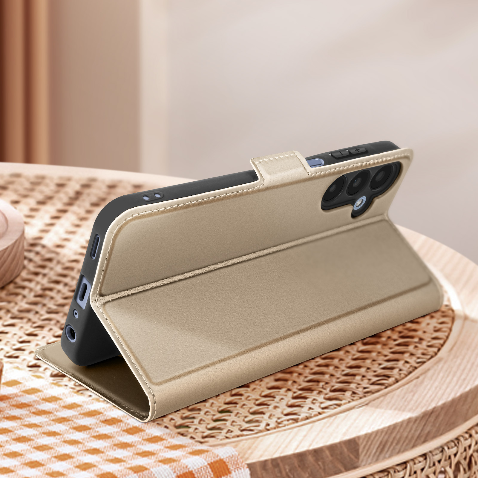 Custodia per telefono dorata su un tavolo di legno. La custodia è aperta. Il telefono è nella custodia.