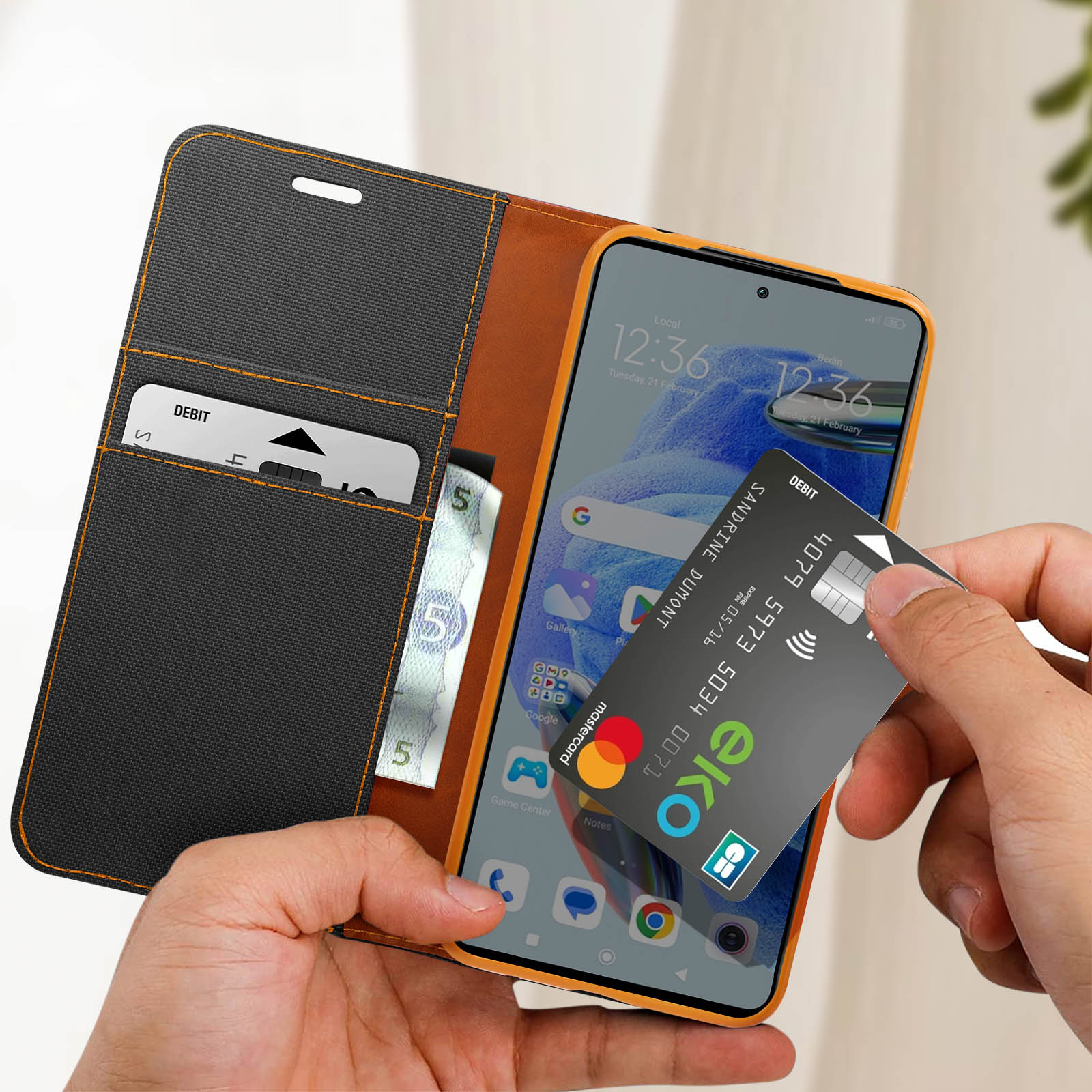 Mano che tiene una custodia per telefono con telefono all'interno e una carta di credito.