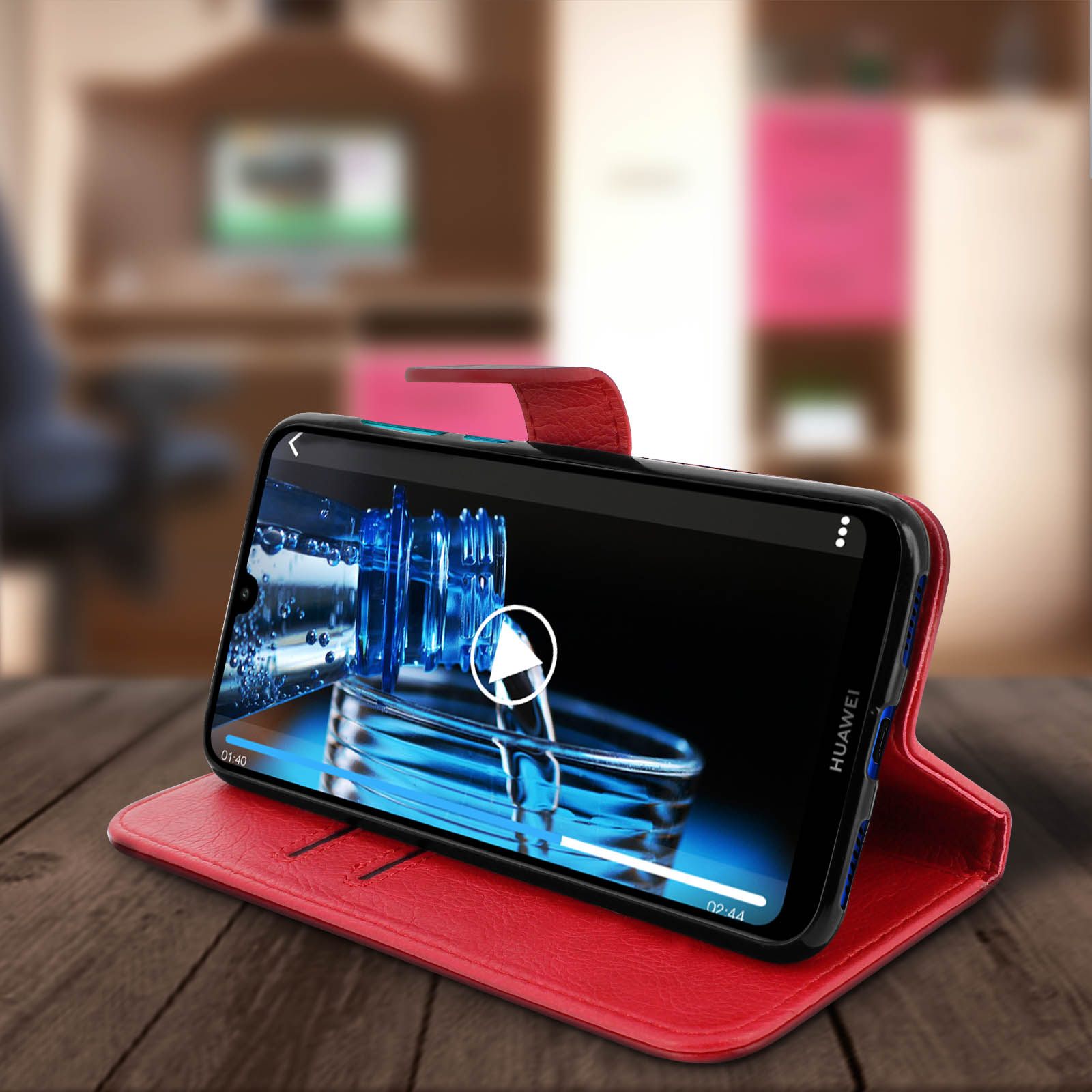 Un telefono in una custodia rossa su un tavolo di legno, che riproduce un video.