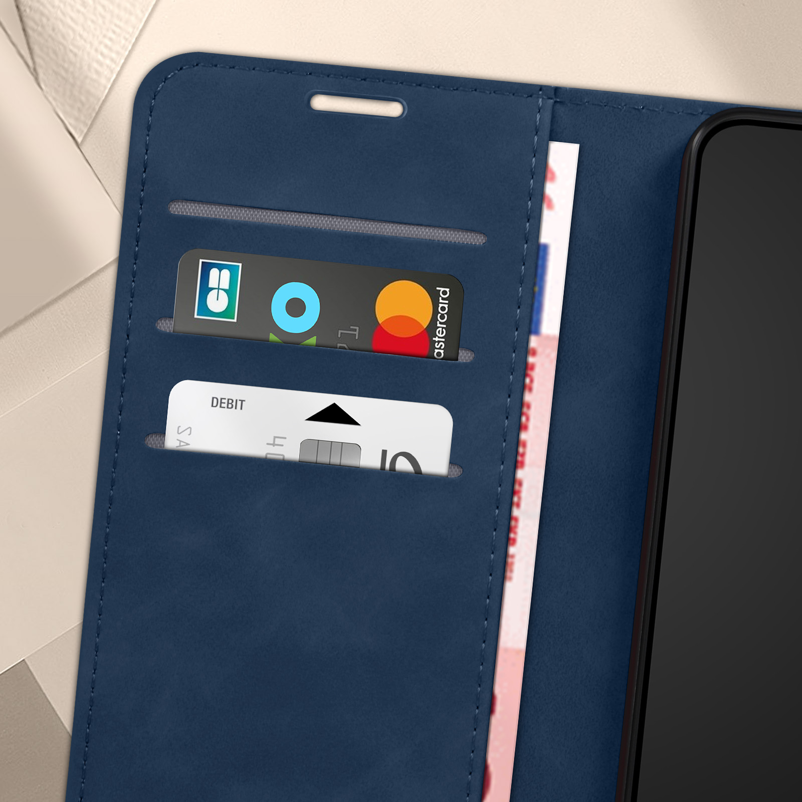 Custodia blu aperta, con carta di credito e di debito visibili. Il telefono è nero.