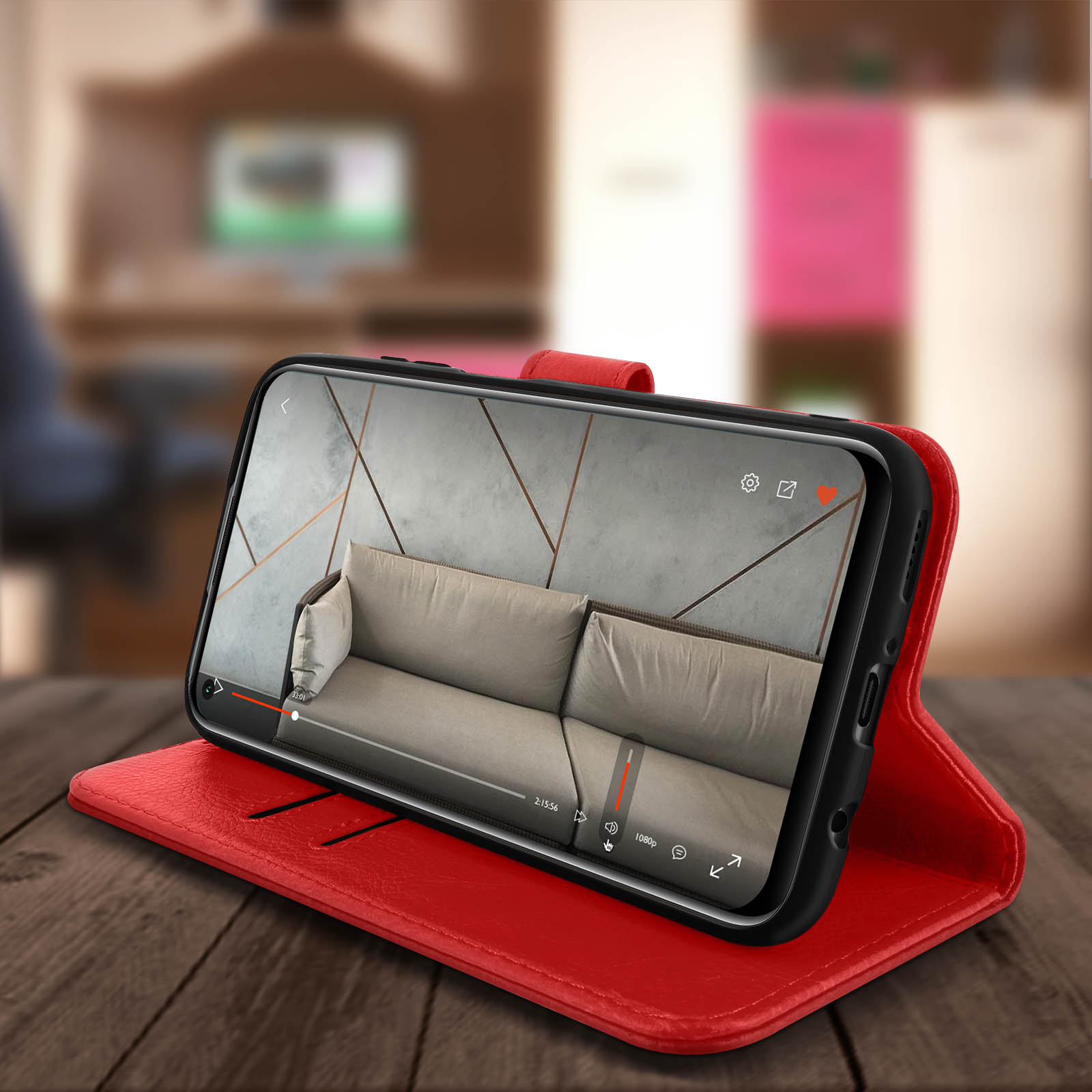 Custodia rossa aperta, mostra telefono che riproduce video. Tavolo in legno scuro. Sfondo sfocato.