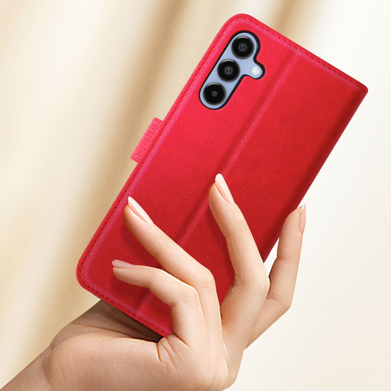 Mano che tiene una custodia rossa con un telefono dentro. Il telefono ha 3 fotocamere.