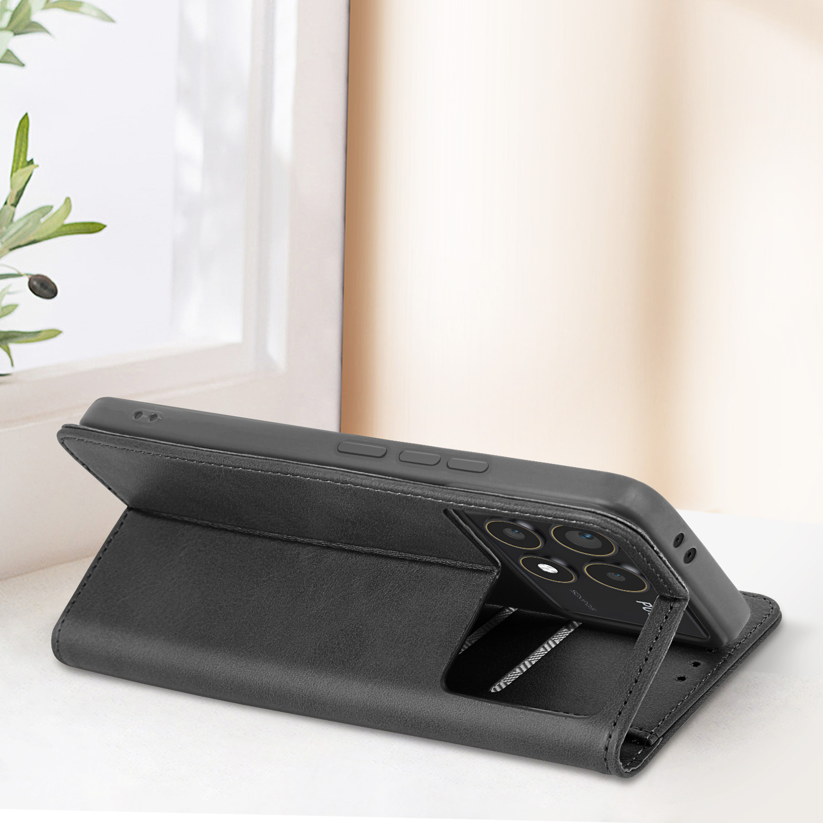 Schwarze Leder-Handyhülle mit Ständerfunktion. Telefon ruht auf dem Ständer. Weiße Oberfläche.
