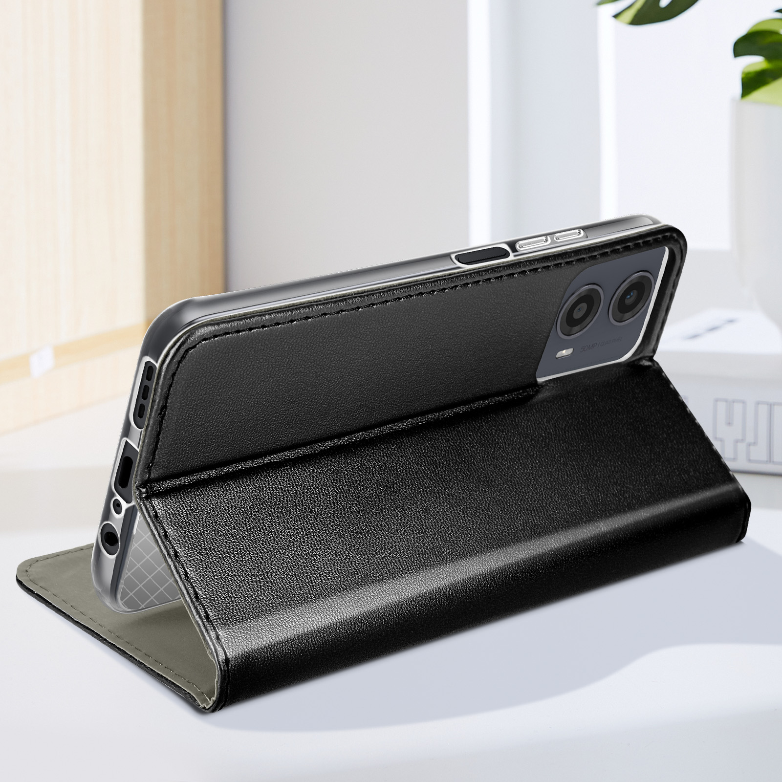 Schwarze Leder-Handyhülle mit Telefon darin, steht auf einem Tisch. Das Telefon ist angewinkelt.