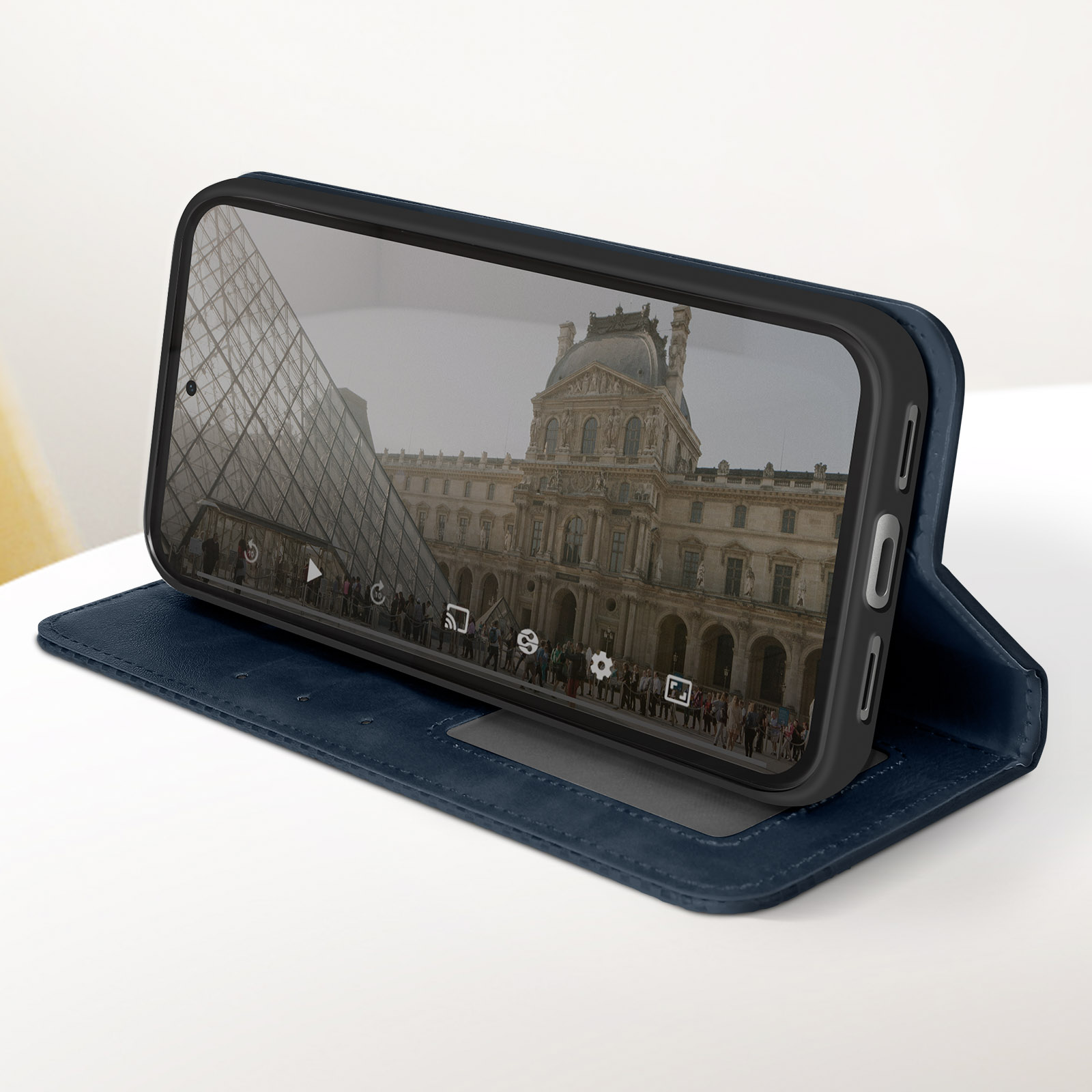 Custodia blu con telefono che mostra un edificio storico. Sul tavolo bianco.
