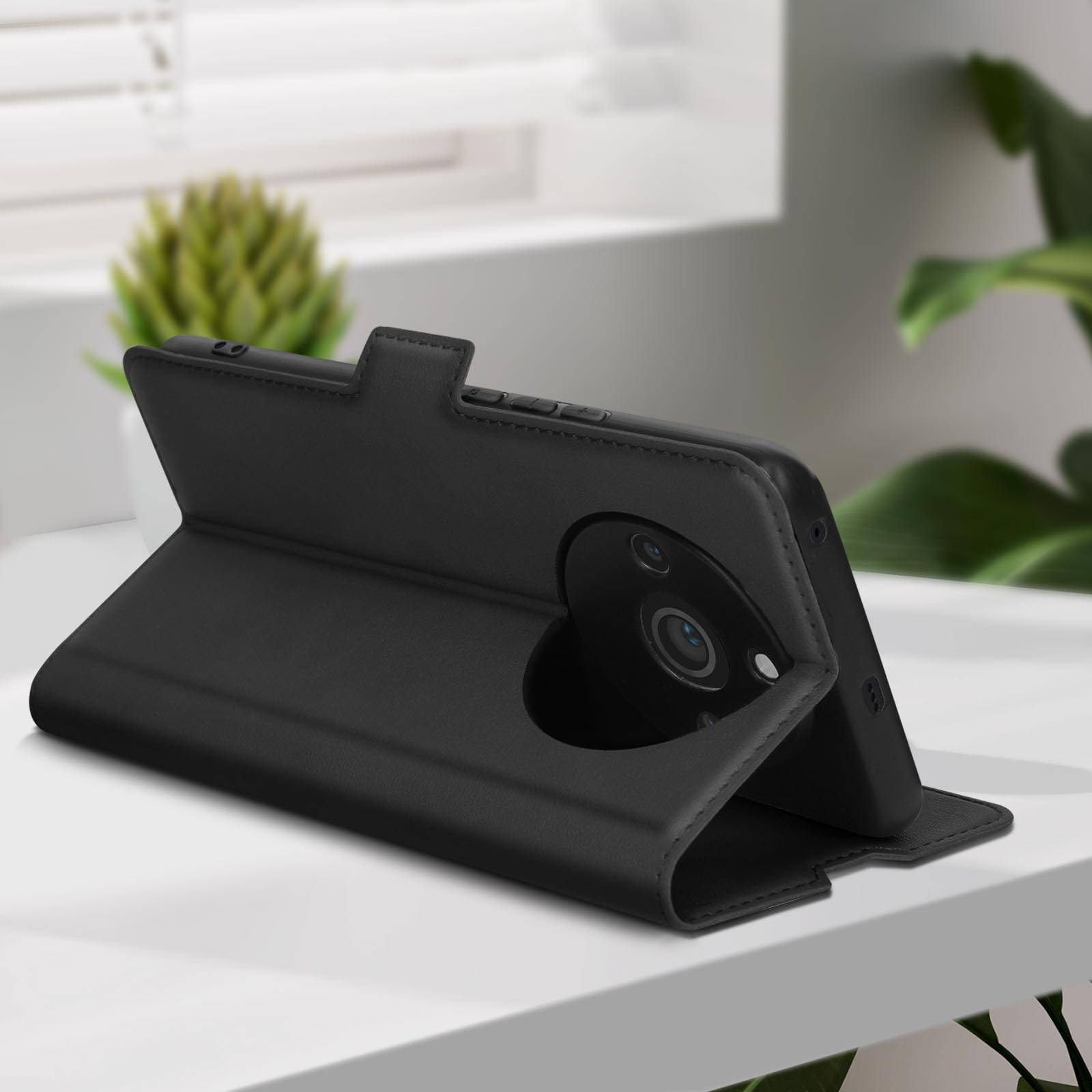 Custodia per telefono in pelle nera aperta. Il telefono è all'interno, la fotocamera è visibile. Lo sfondo è sfocato.