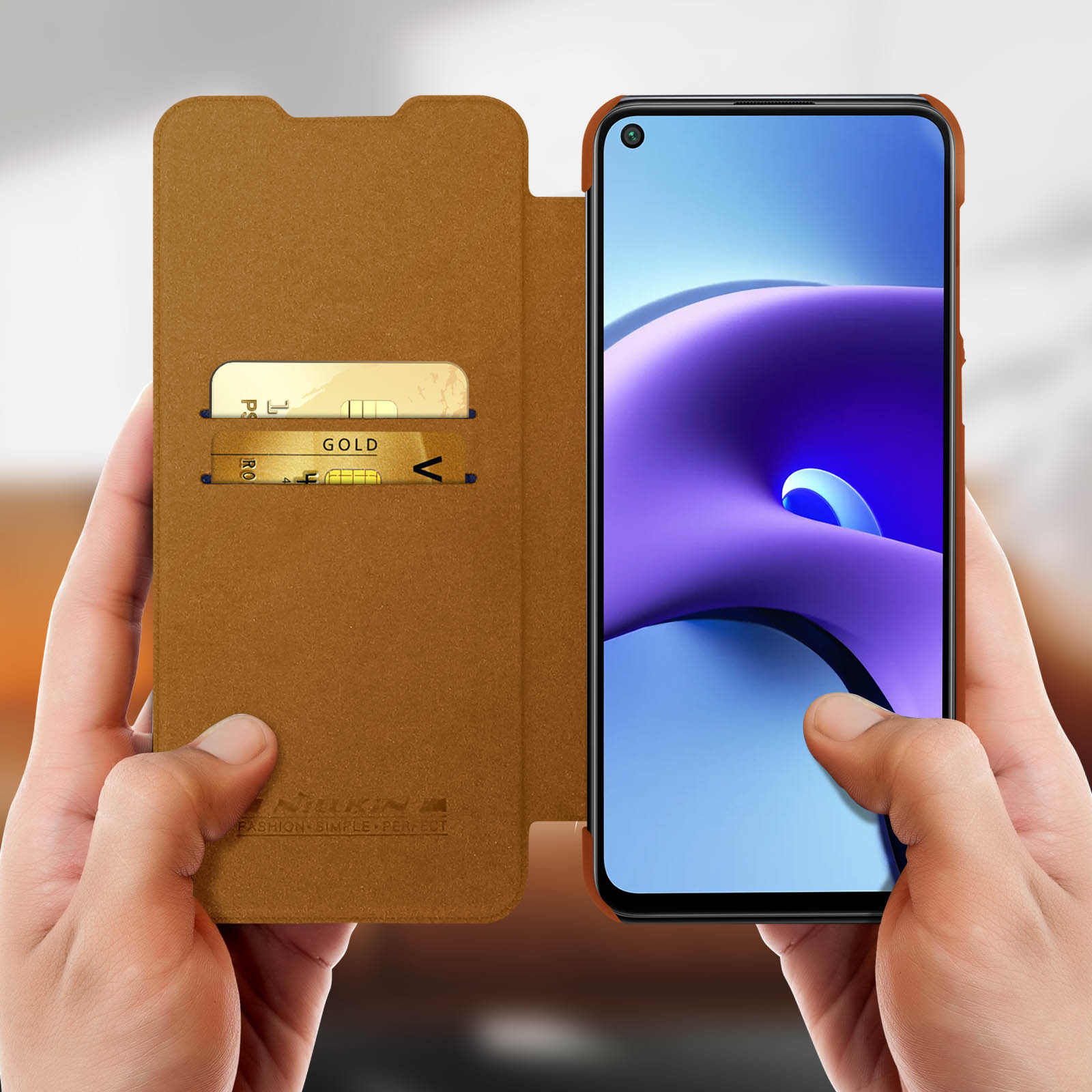 Mani che tengono una custodia per telefono marrone con carte e un telefono. È visibile uno schermo del telefono viola.