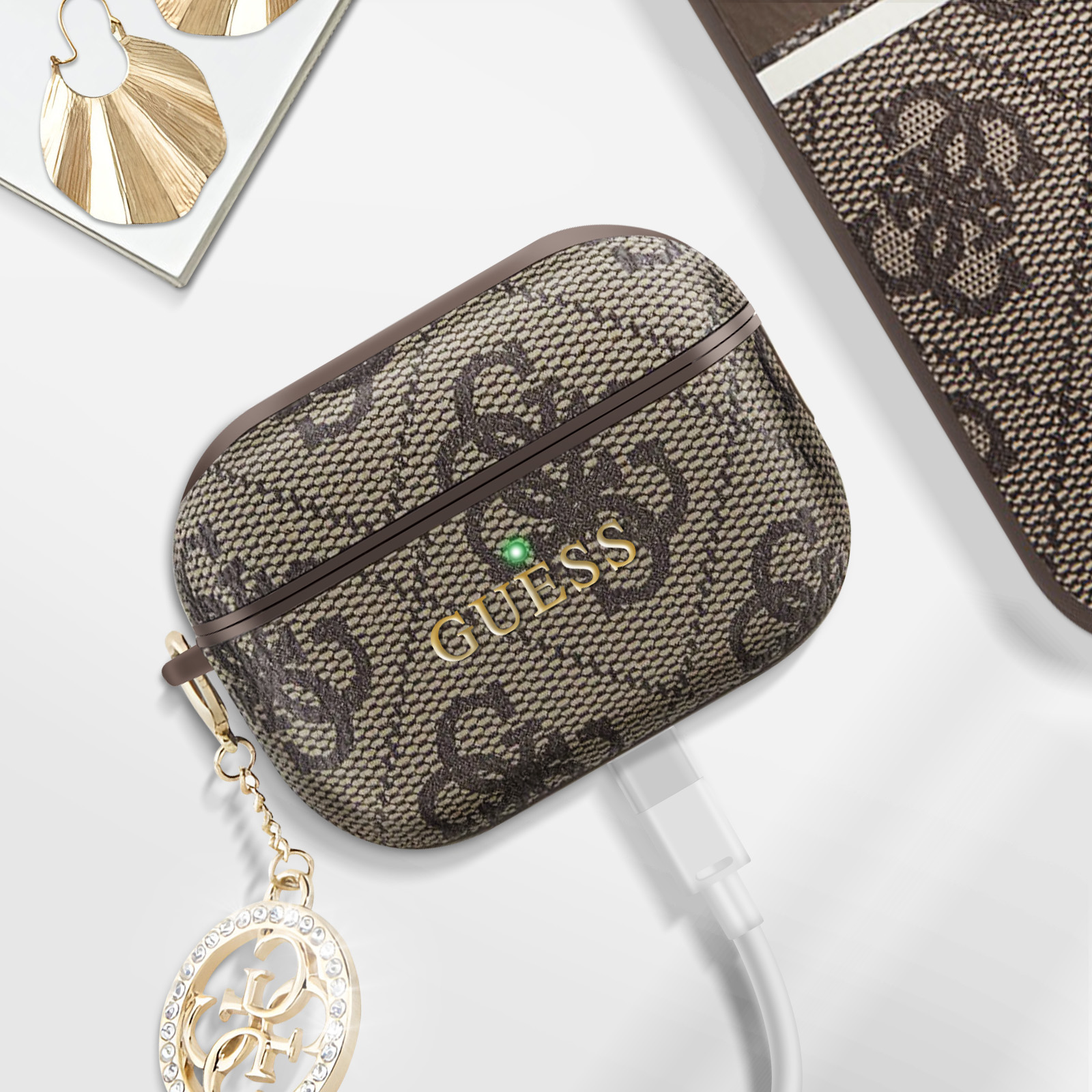 GUESS AirPod-Hülle mit goldener Kette und Ladekabel.