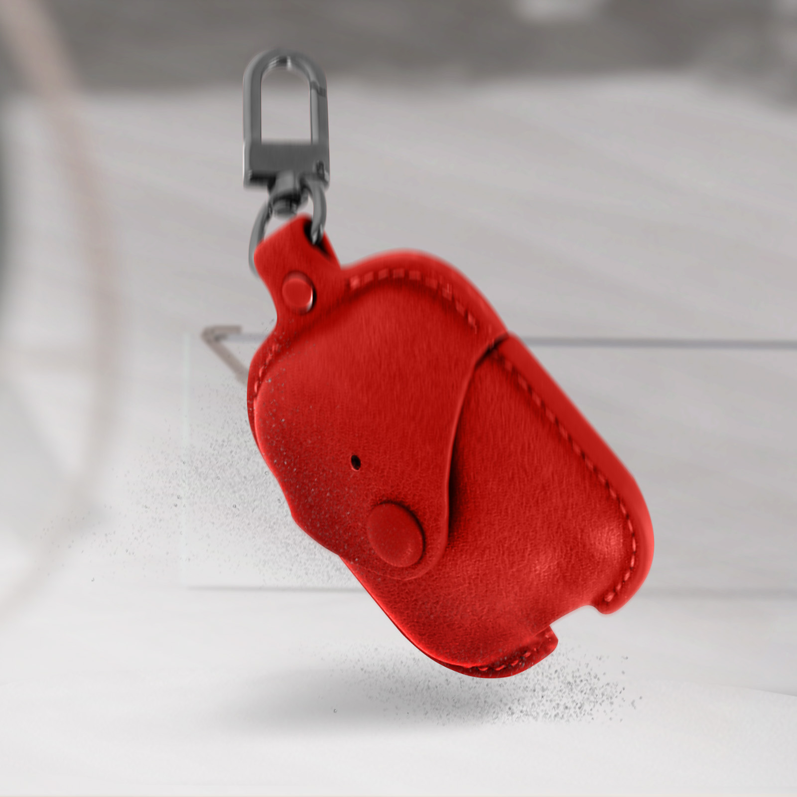 Funda de AirPod roja con forma de elefante con llavero plateado, sobre fondo blanco.