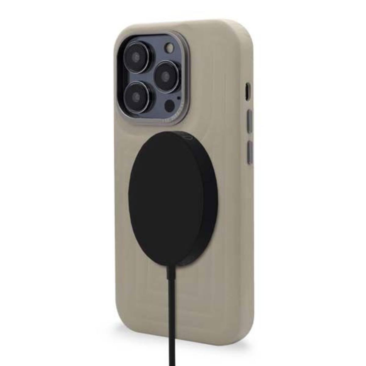 Una custodia beige con un caricabatterie MagSafe nero attaccato. La custodia è su una superficie bianca.