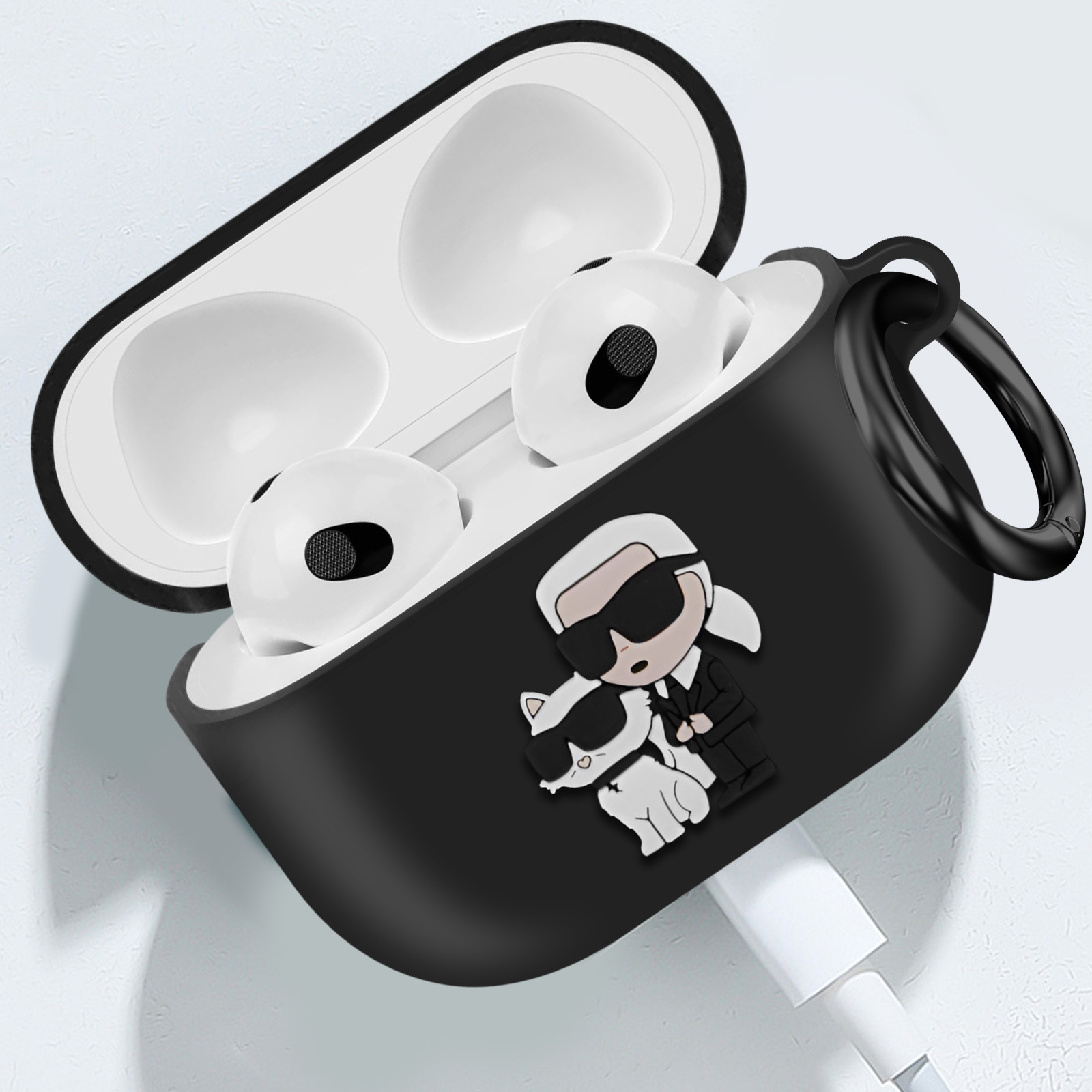 Estuche negro para auriculares con personajes de dibujos animados y un cable de carga. El estuche está abierto.