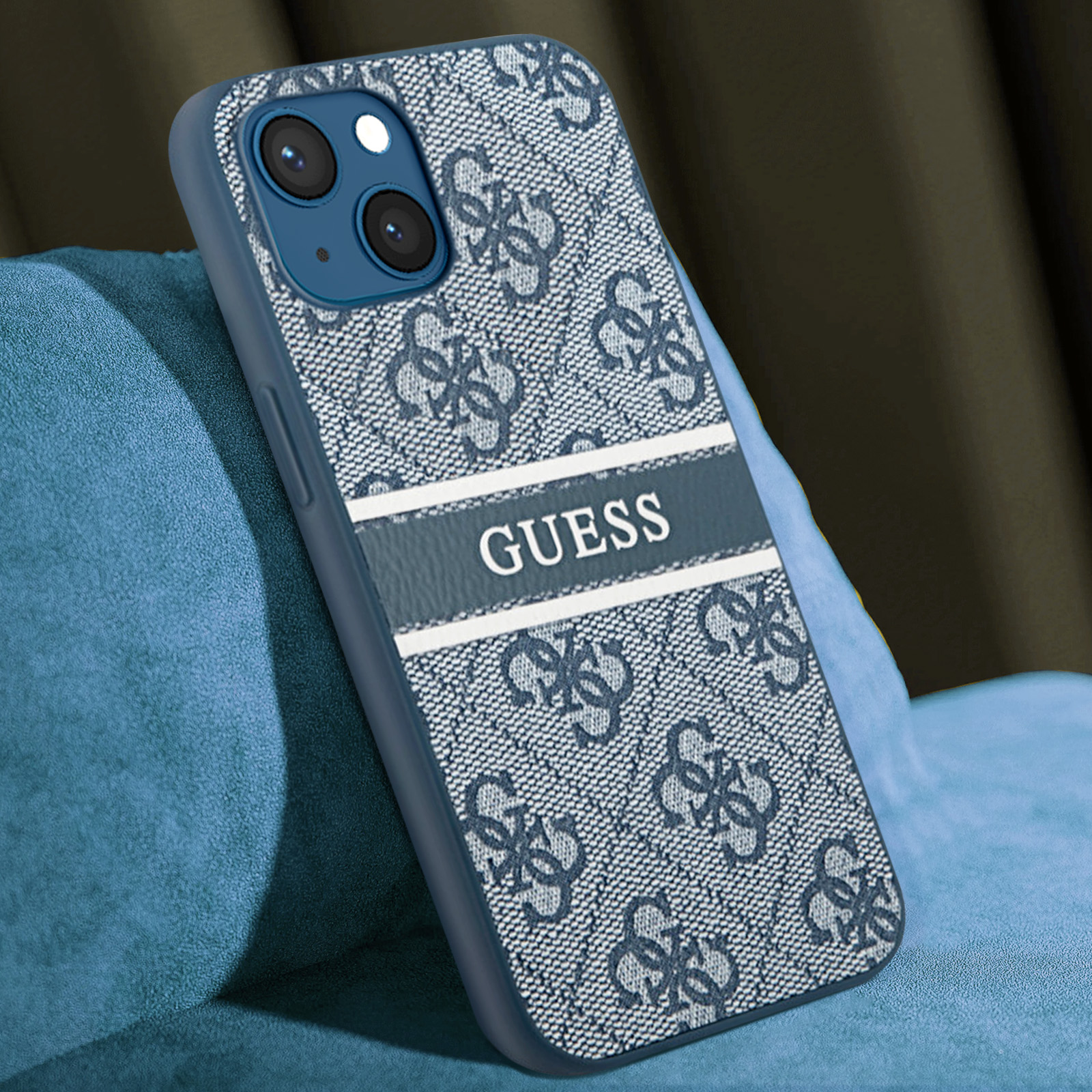 Custodia blu per iPhone con logo GUESS e motivo floreale. Su superficie blu.