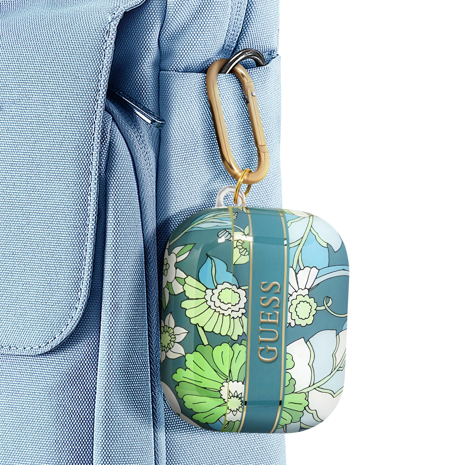 Funda floral Guess para AirPods, de color verde azulado, sujeta a una correa de mochila azul con mosquetón dorado.