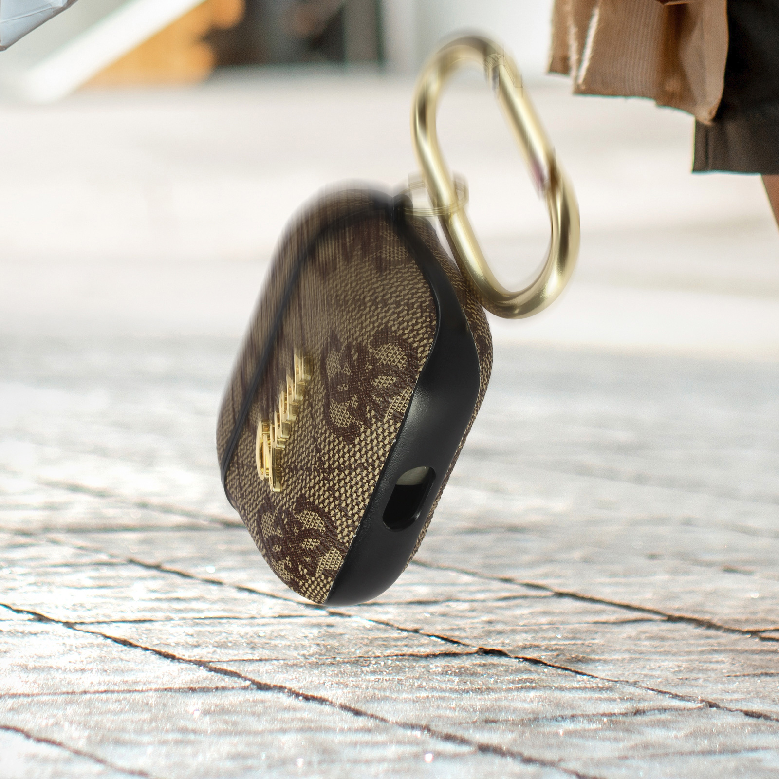 Funda de auriculares marrón y negra con mosquetón dorado.