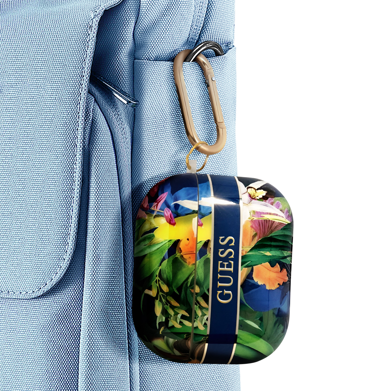 Estuche para auriculares en una bolsa azul. El estuche tiene un diseño floral y un logo Guess.