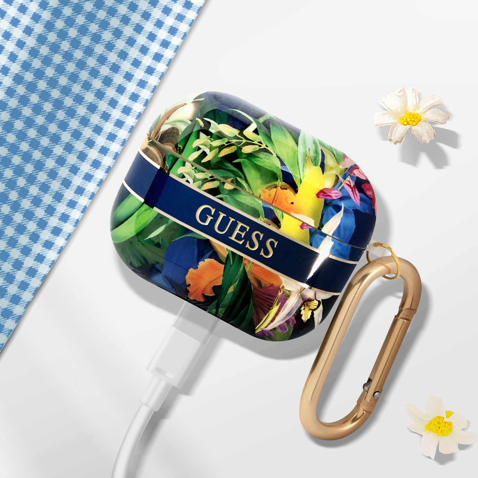 Una funda floral GUESS AirPods con un cable de carga y un mosquetón dorado.